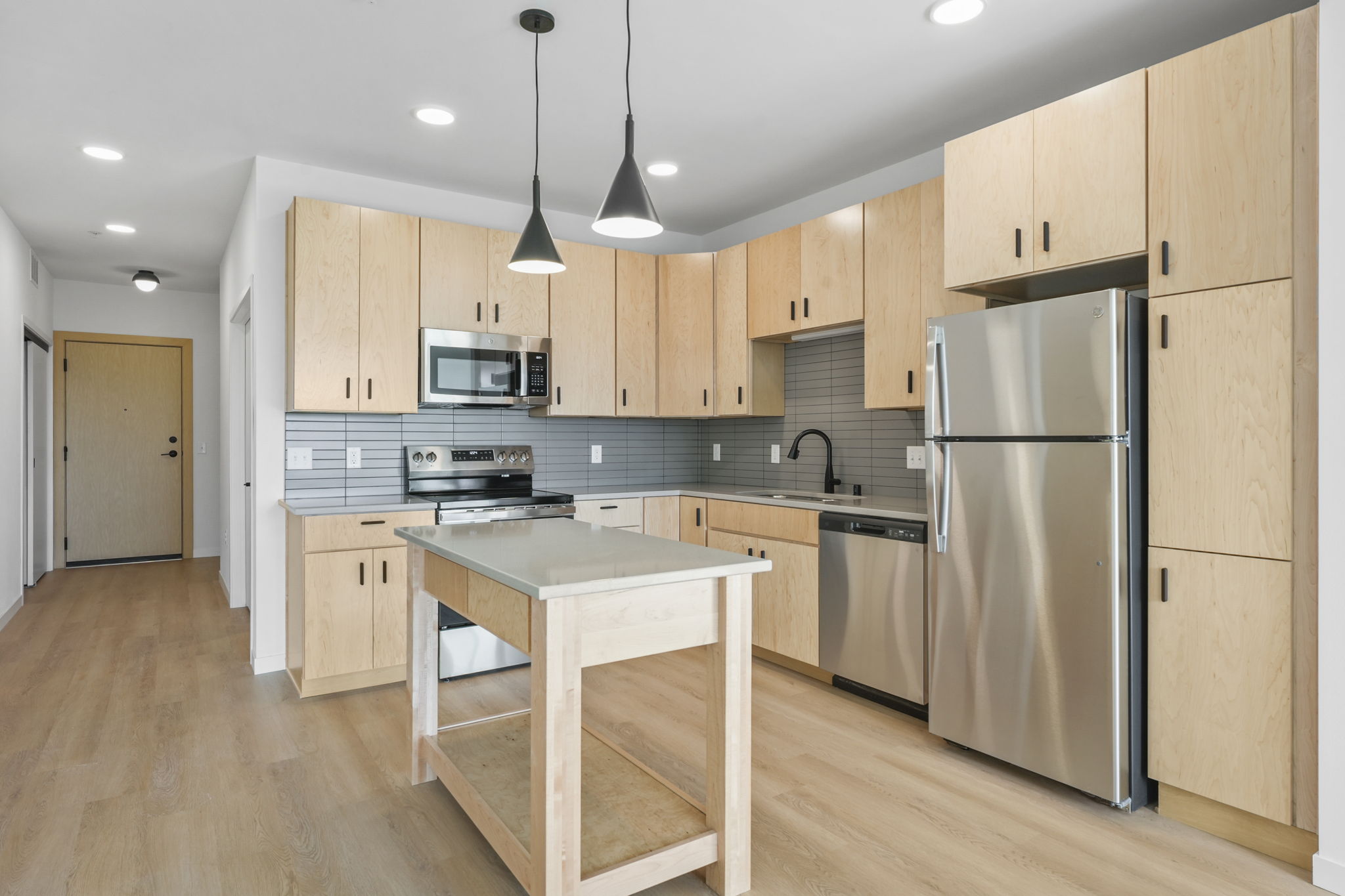 Stunning kitchen at The Irwin with cabinetry, countertops, and open layout to living space