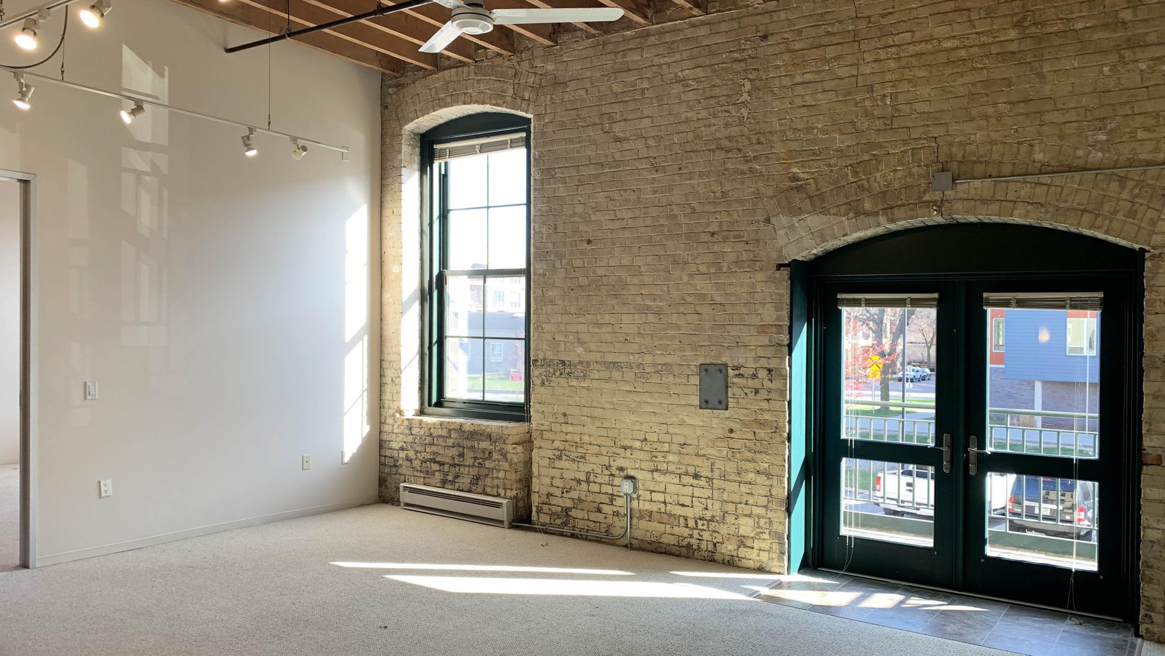 Tobacco-Lofts-At-The-Yards-Apartment-E213-Two-Bedroom-Living-Room-Balcony-Historic-Design-Exposed-Brick-Timber-Beams-Downtwon-Madison-Bike-Lake-Cats-Fitness