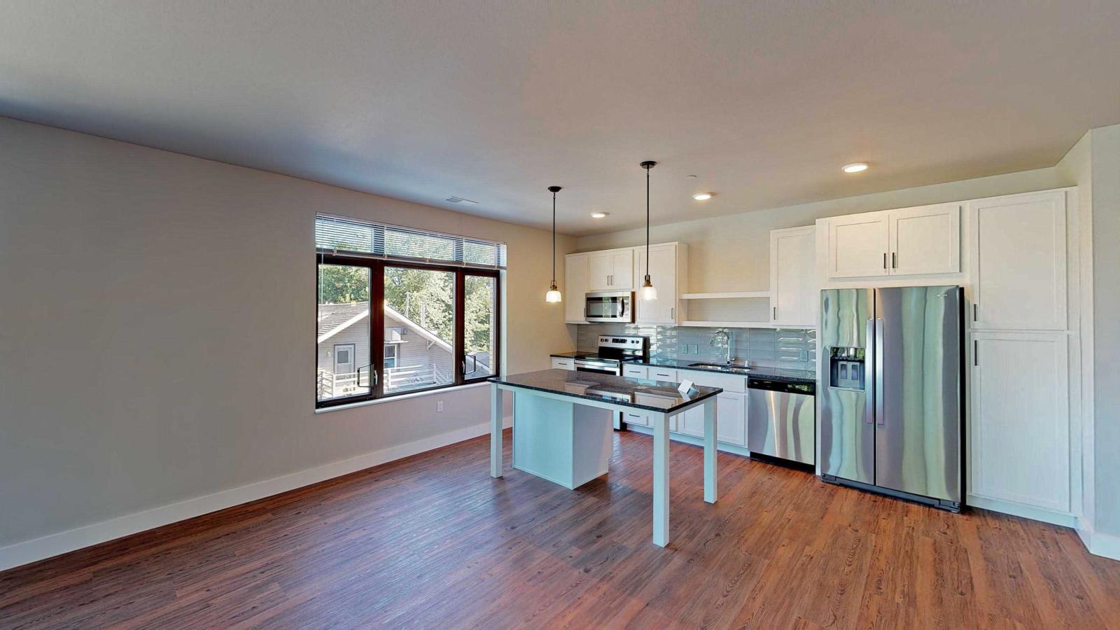 Modern kitchen in a 1722 Monroe apartment in Madison with white cabinetry, quartz countertops, and stainless steel appliances.