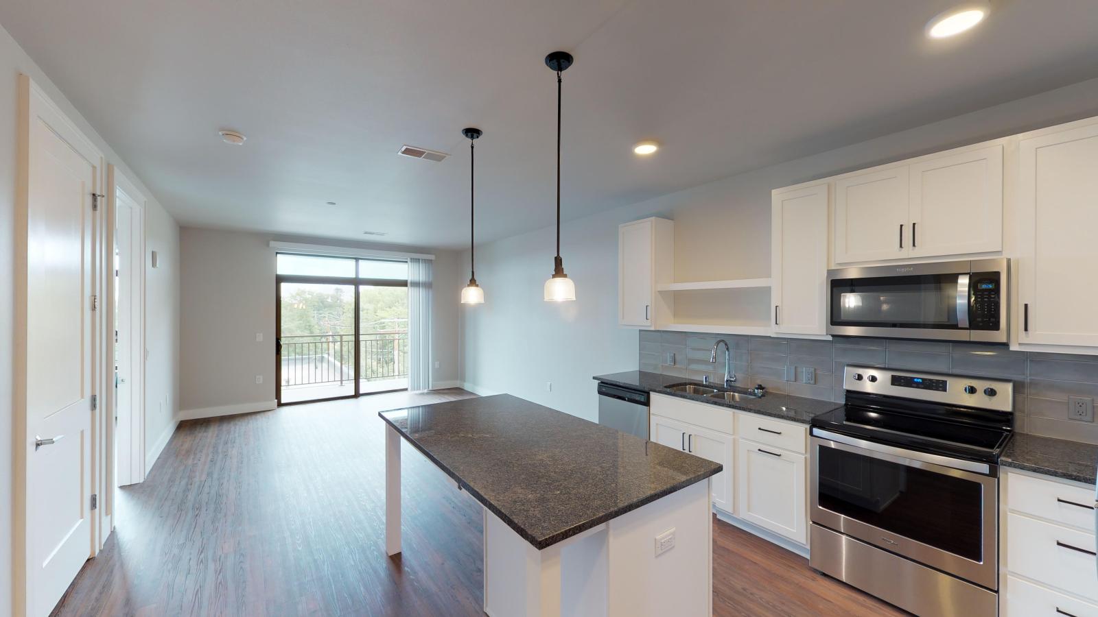 One bedroom with open living and kitchen, and balcony looking neighborhood at 1722 Monroe Apartments in Madison