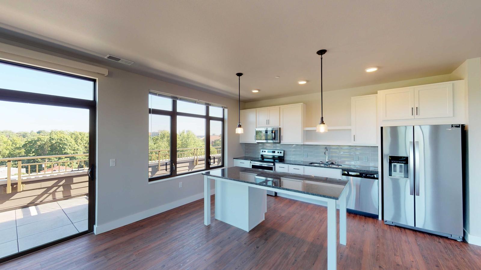 Modern kitchen in a 1722 Monroe apartment in Madison with white cabinetry, quartz countertops, and stainless steel appliances.