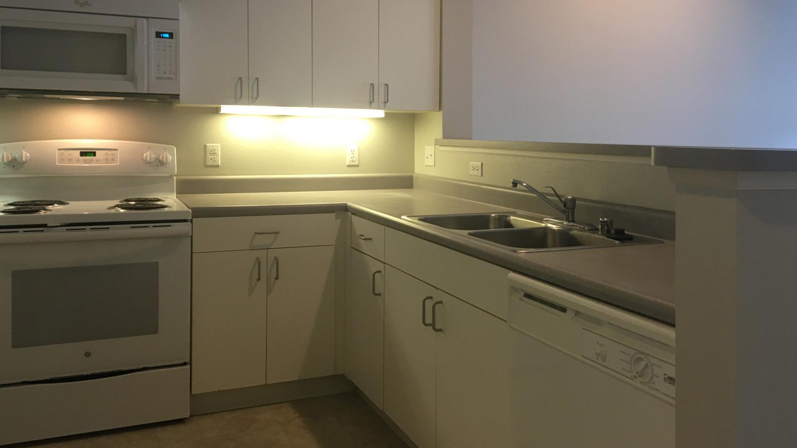 Kitchen with classic cabinetry and full-size appliances in a one-bedroom at Wilson Bay