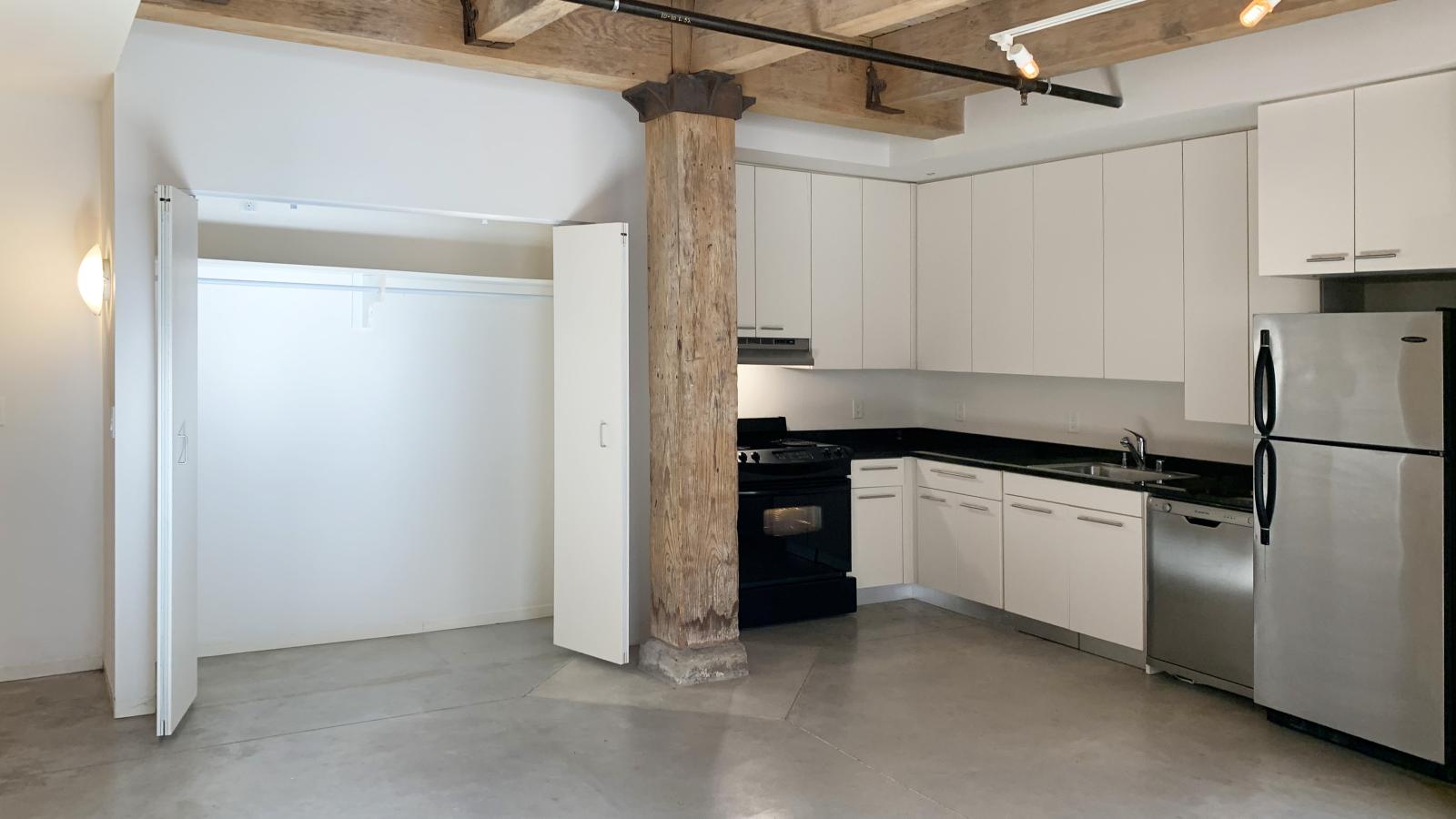 One bedroom apartment with an open kitchen, granite countertops, and stainless steel appliances at Tobacco Lofts