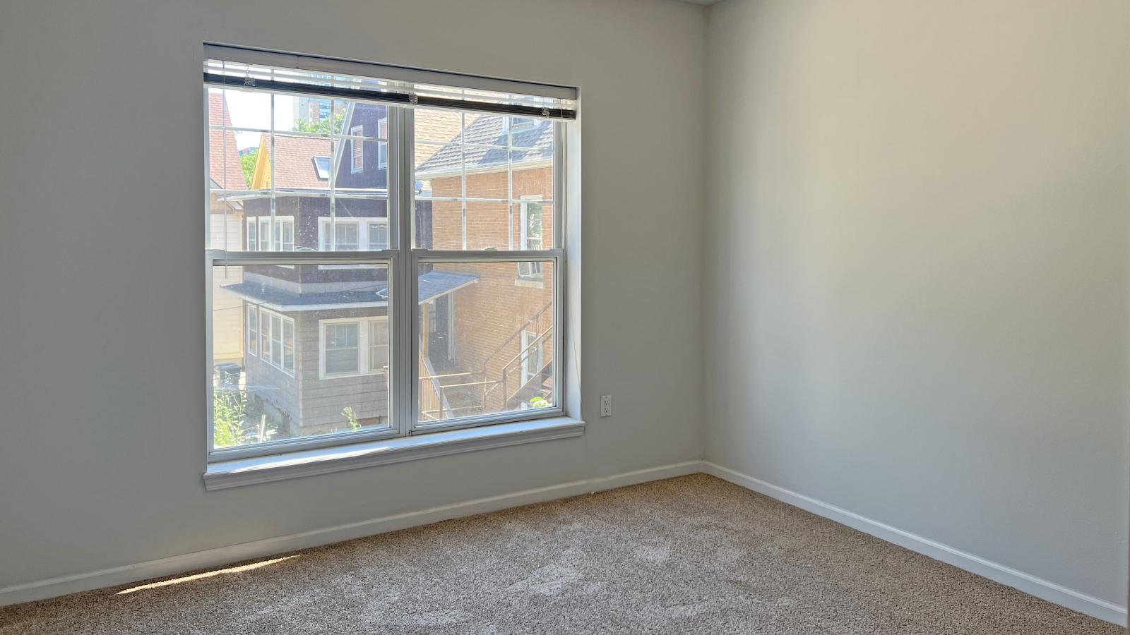 Bright bedroom with large windows and soft finishes at City Place