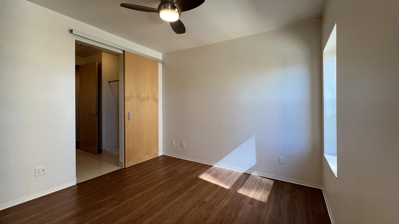 Spacious bedroom with ample storage and large windows at Capitol Hill Apartments