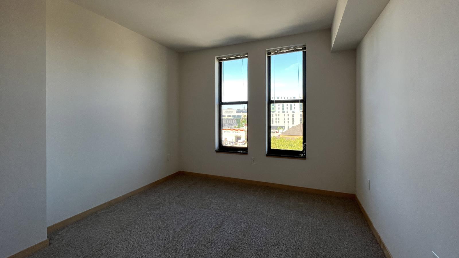 One bedroom apartment with a walk in closet and large windows at The Depot in downtown Madison