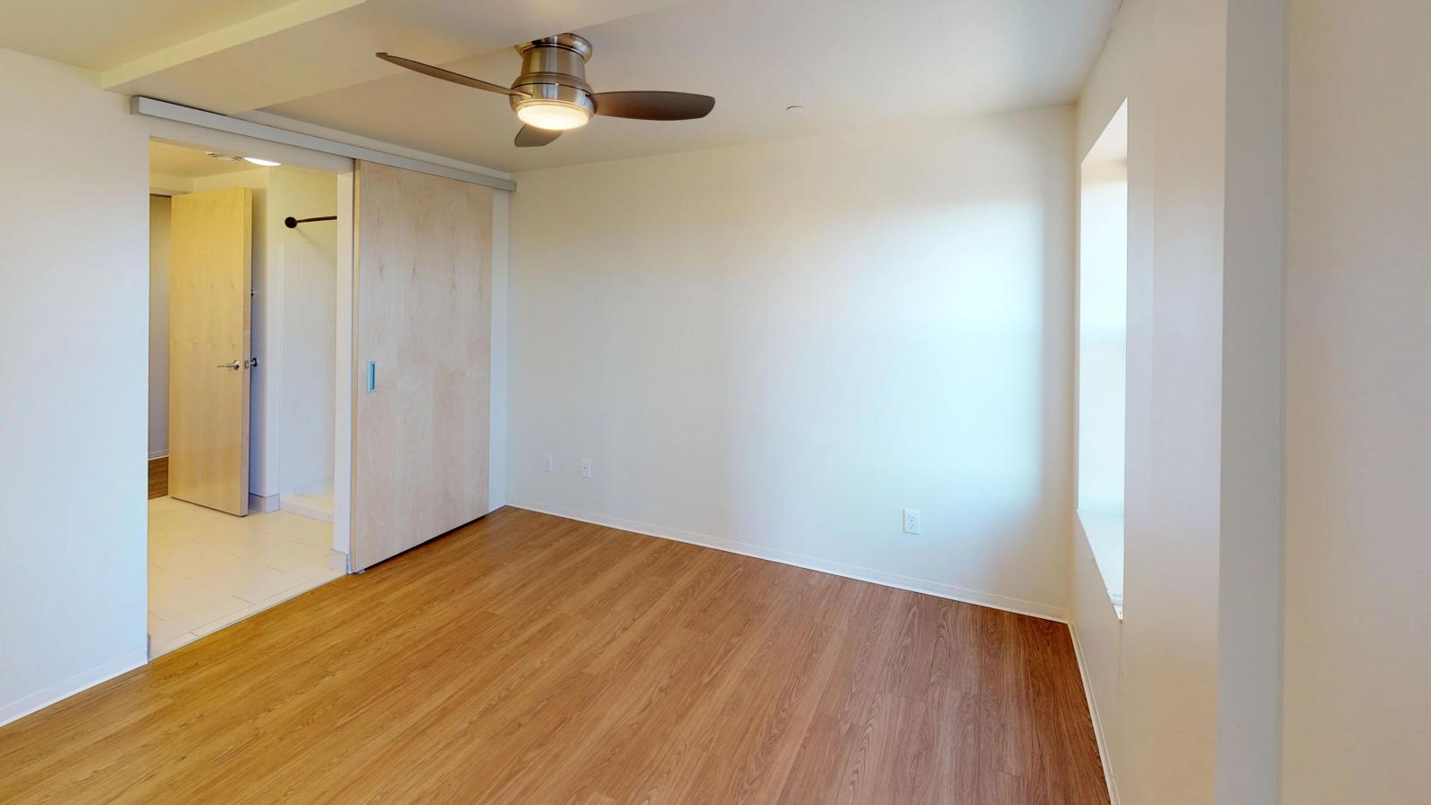 Spacious bedroom with ample storage and large windows at Capitol Hill Apartments