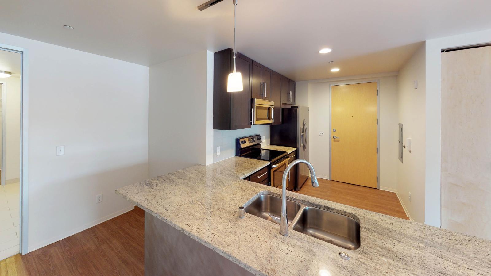Kitchen with granite countertops, stainless steel appliances, and brushed aluminum backed island at Capitol Hill