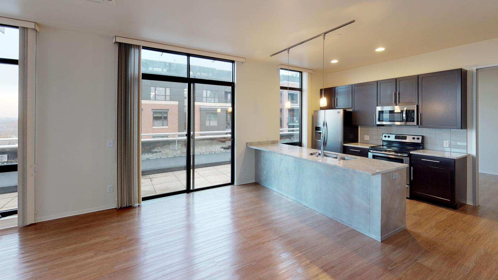 Top floor Two bedroom apartment kitchen with brushed aluminum backed island and stainless steel appliances at Capitol Hill