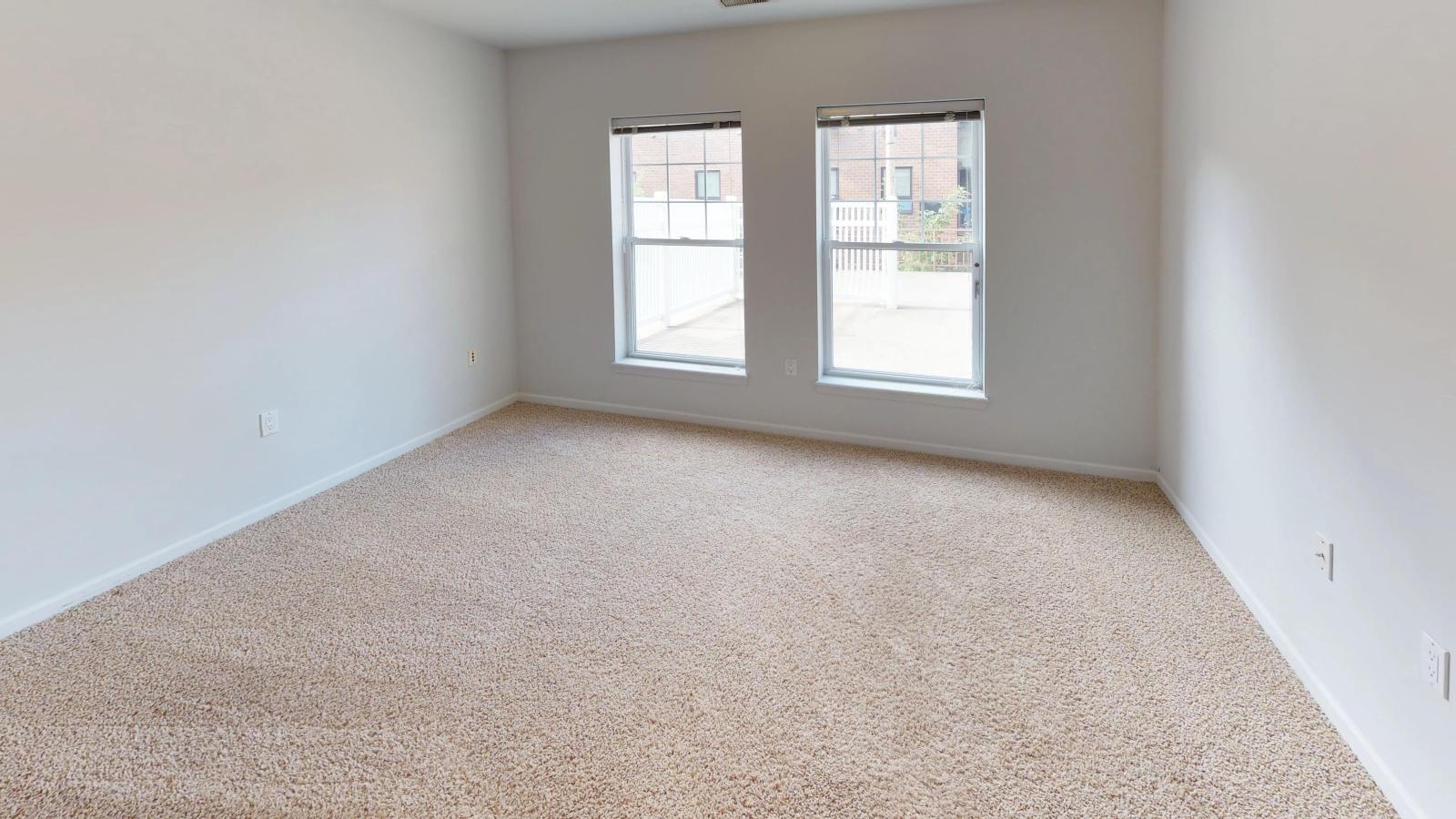Bright bedroom with large windows and soft finishes at City Place