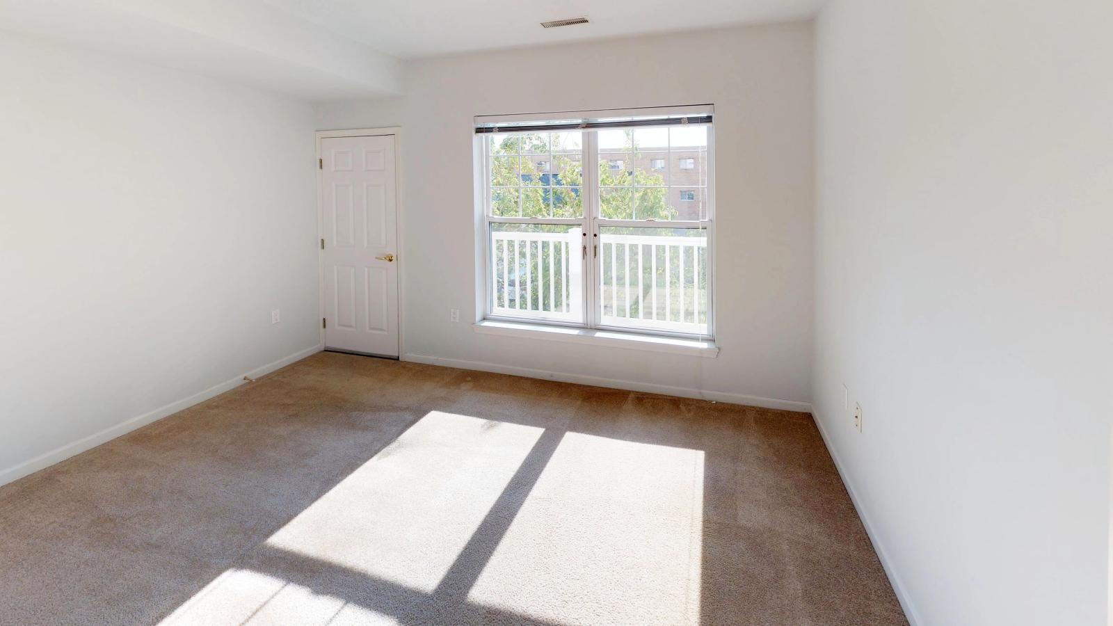 Bright bedroom with large windows and soft finishes at City Place