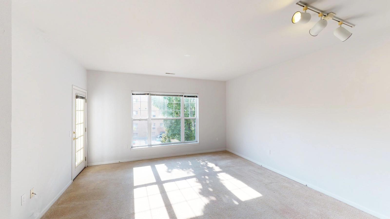 Living room with large windows and natural light in a one-bedroom apartment at City Place