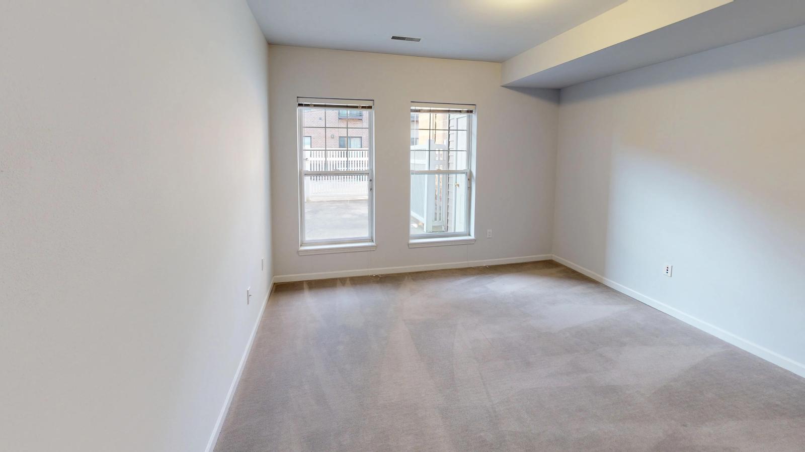 Bright bedroom with large windows and soft finishes at City Place