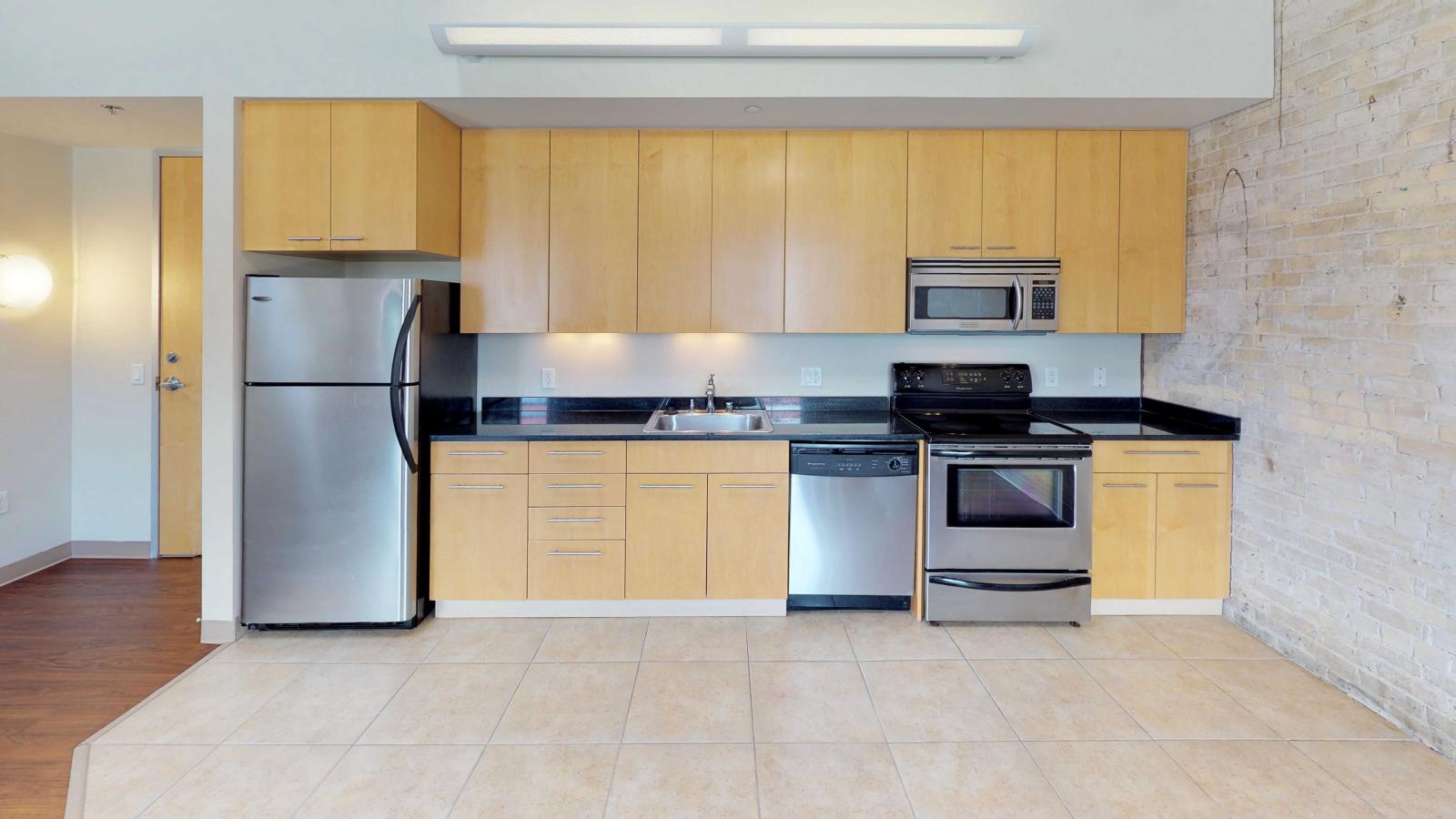 Two bedroom apartment featuring a functional kitchen with an open layout and ample counter space at Tobacco Lofts