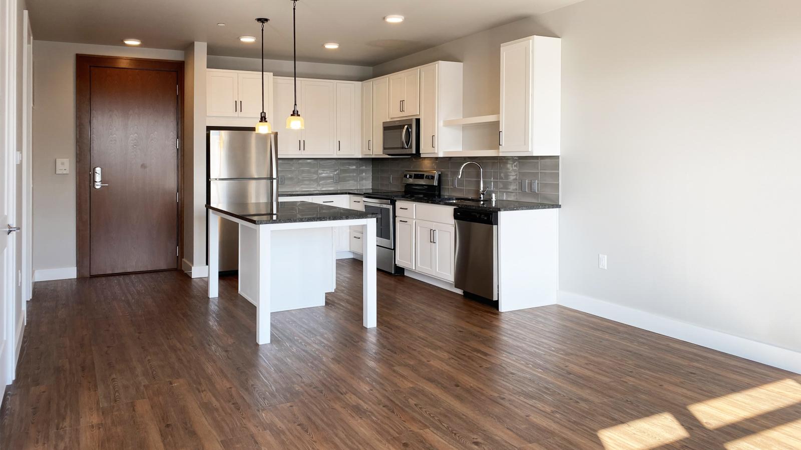 Modern kitchen in a 1722 Monroe apartment in Madison with white cabinetry, quartz countertops, and stainless steel appliances.
