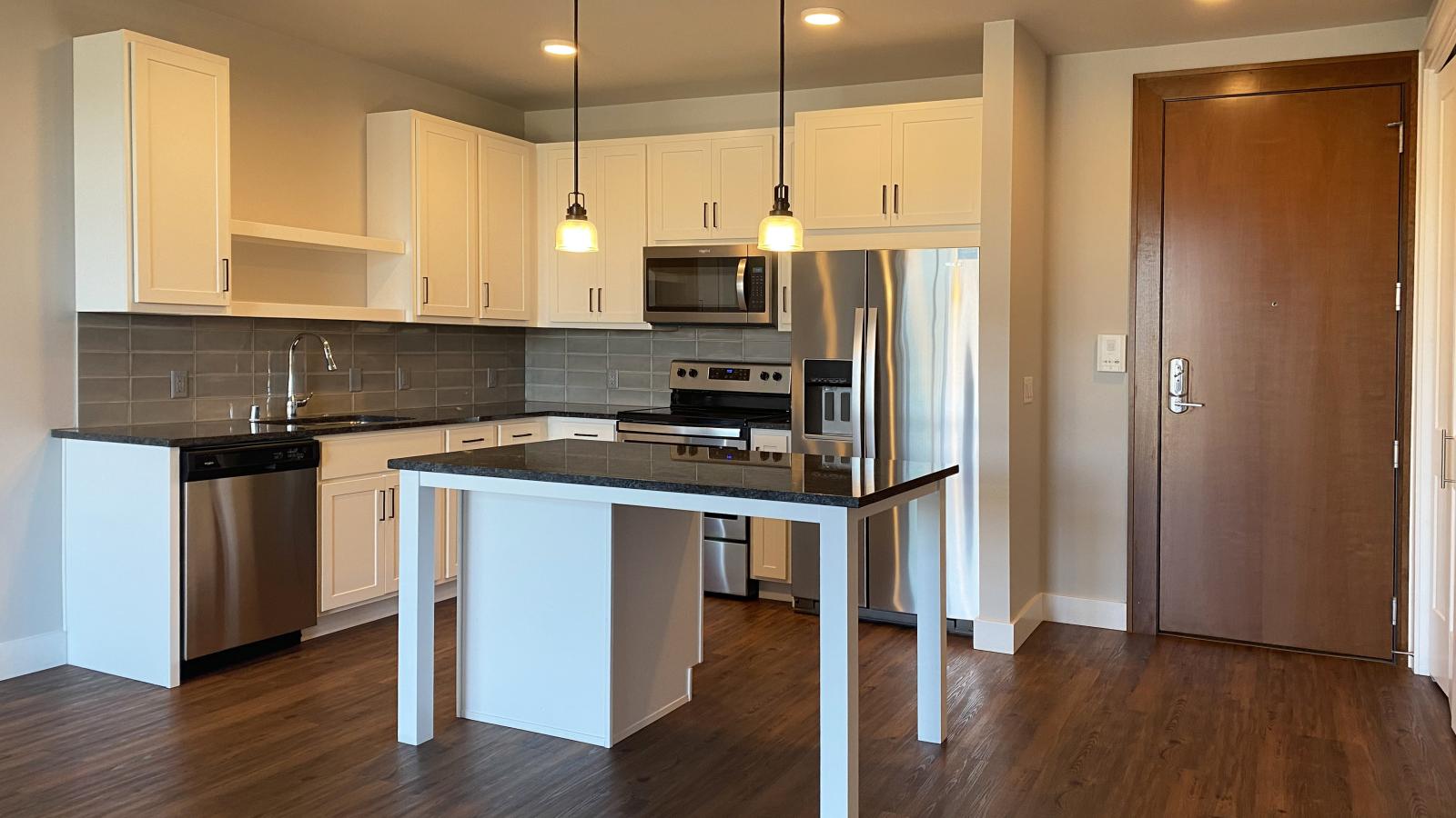 Modern kitchen in a 1722 Monroe apartment in Madison with white cabinetry, quartz countertops, and stainless steel appliances.