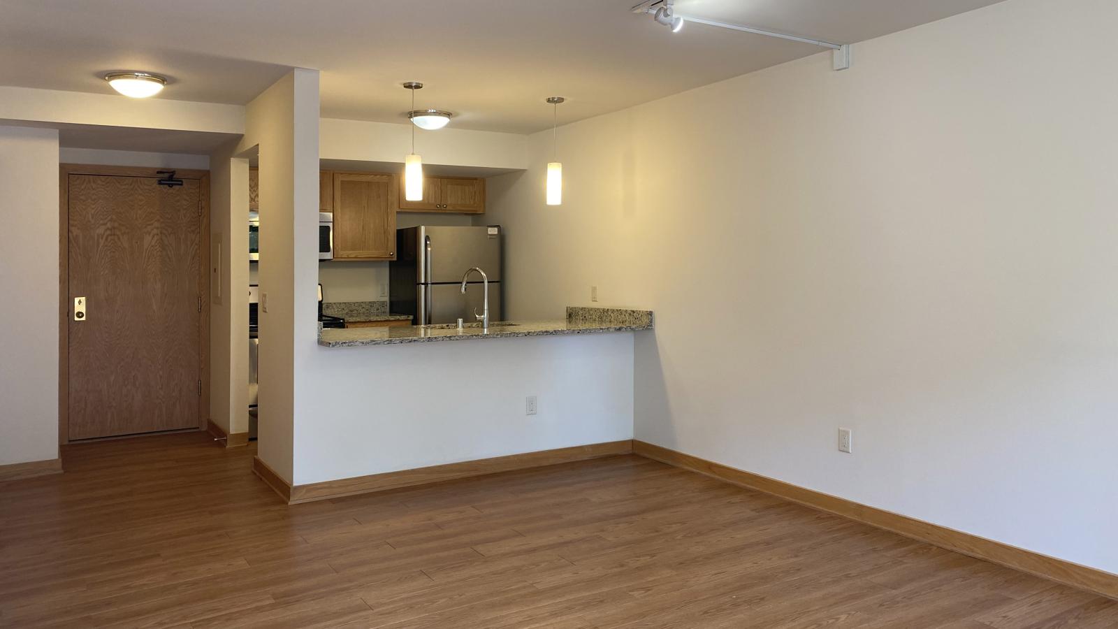 Kitchen with granite countertops, stainless steel appliances, and warm finishes at Lincoln School