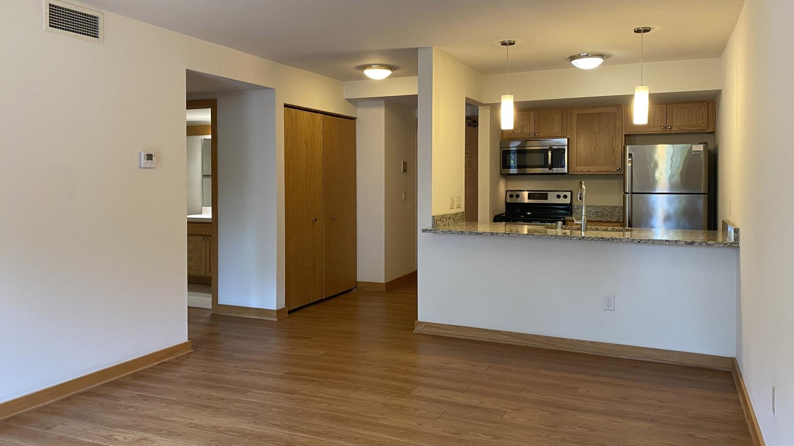 Kitchen with granite countertops, stainless steel appliances, and warm finishes at Lincoln School