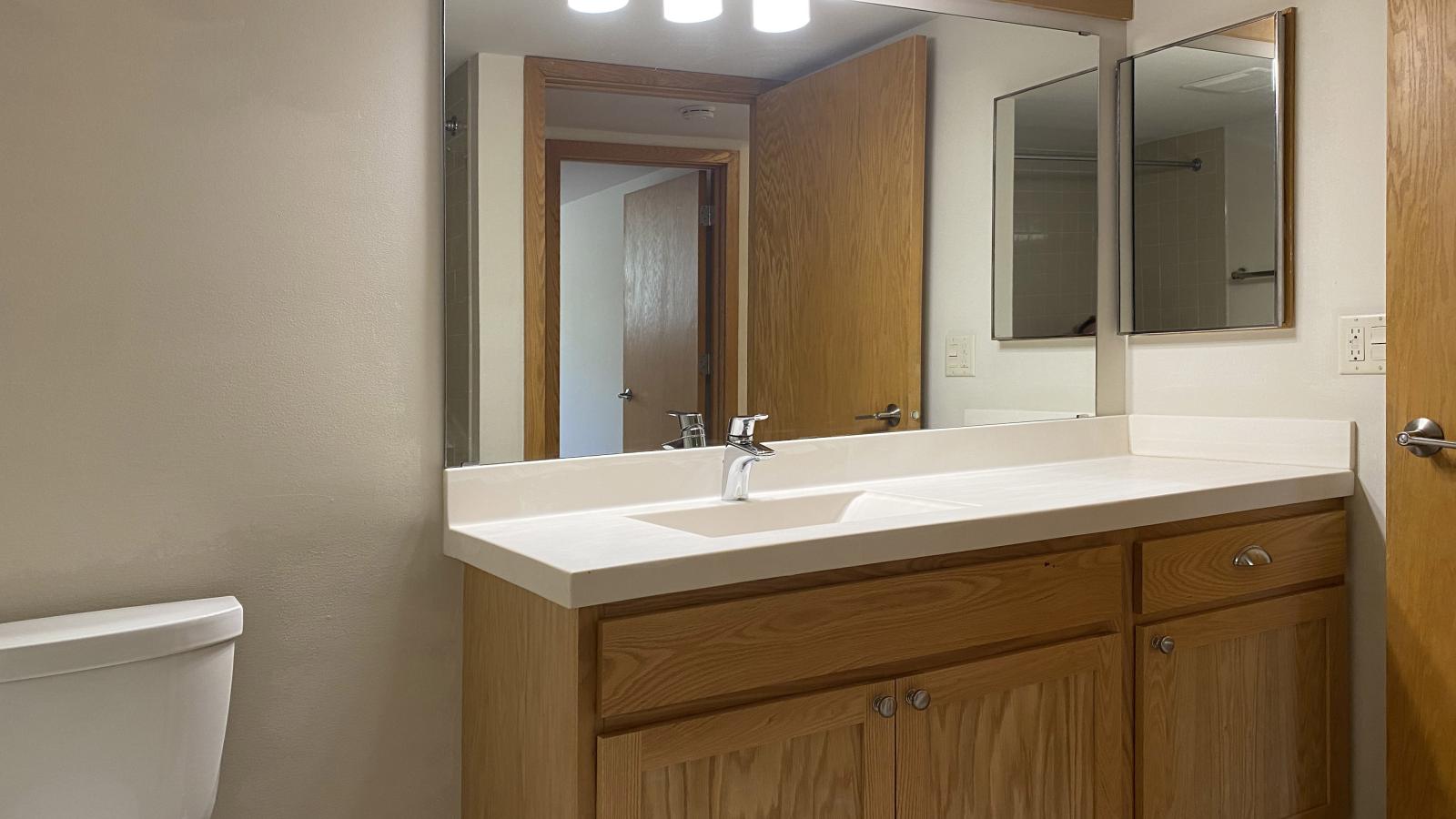 Classic bathroom with tiled finishes and warm lighting at Lincoln School