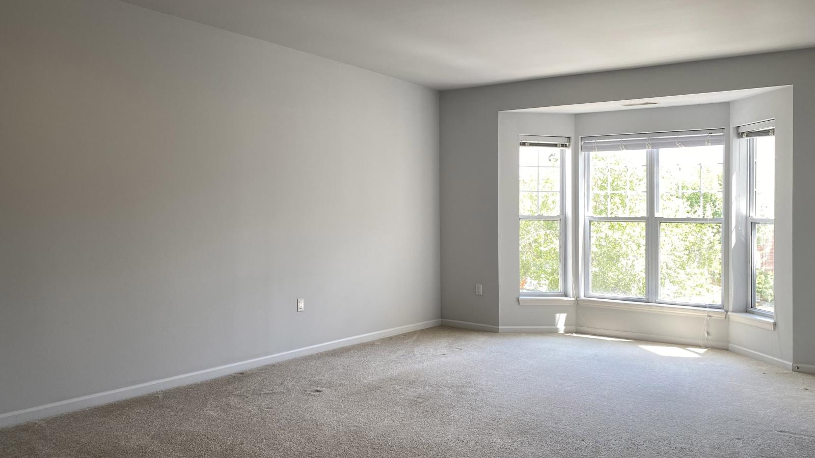 Living room with large bay windows and natural light in a one-bedroom apartment at City Place