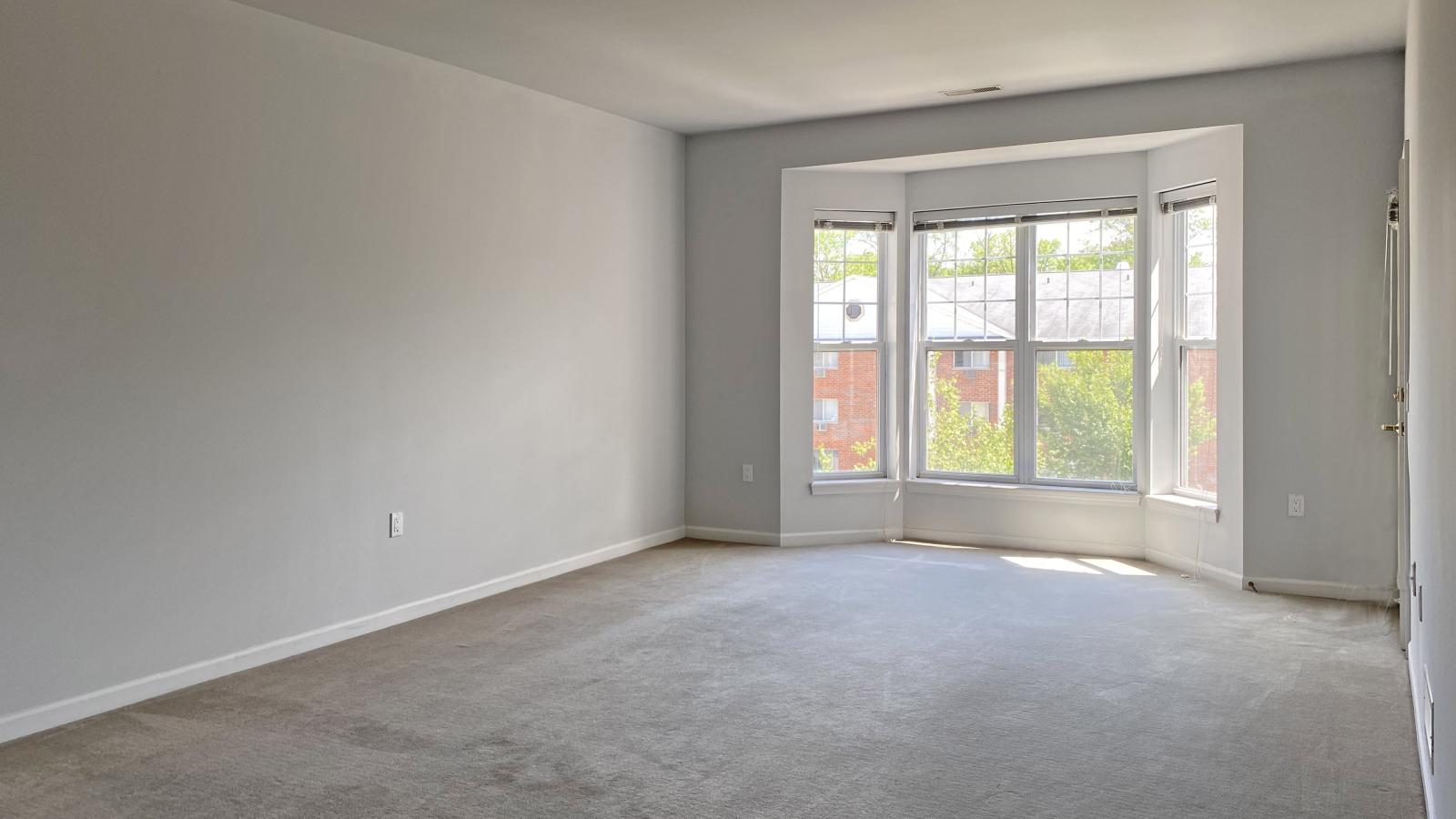 Living room with large bay windows and natural light in a one-bedroom apartment at City Place