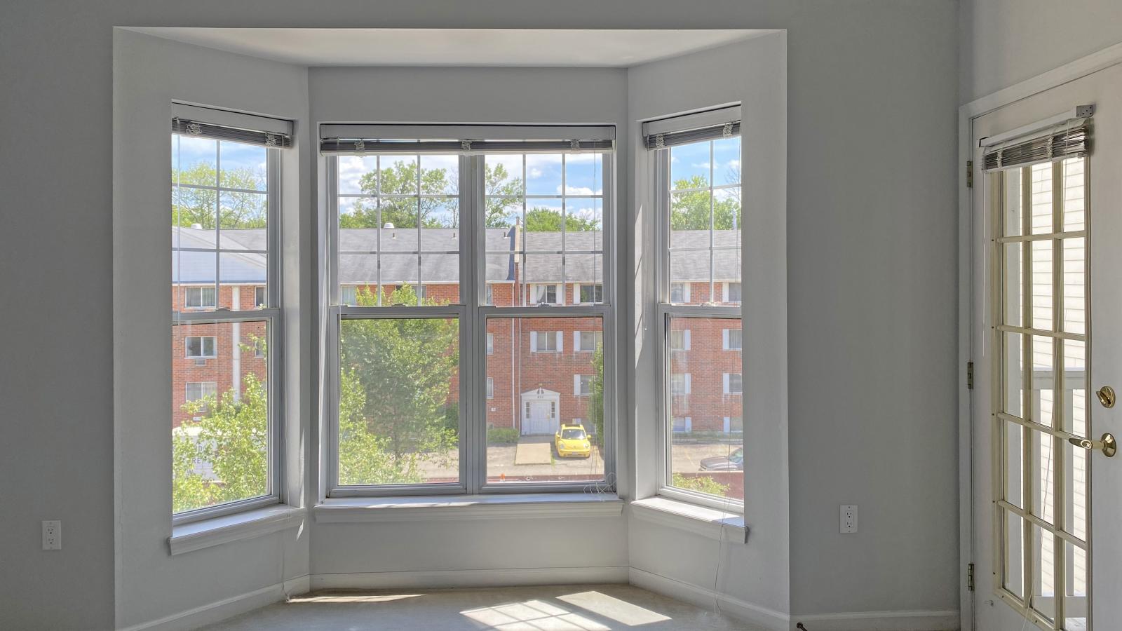 Living room with large bay windows and natural light in a one-bedroom apartment at City Place