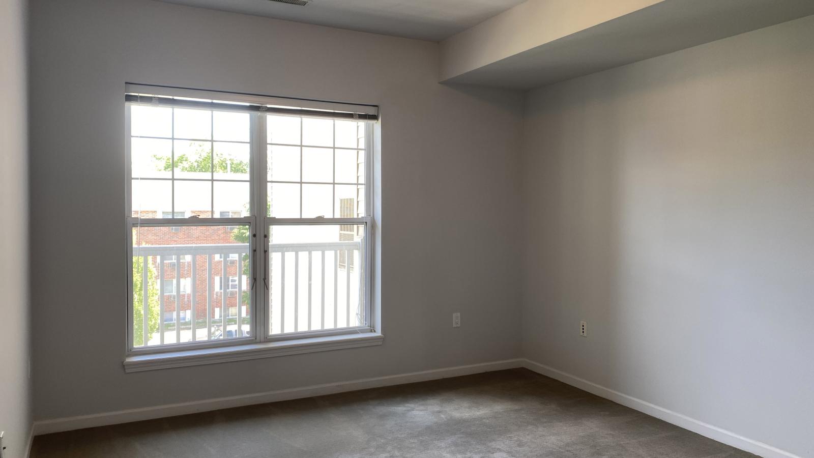 Bright bedroom with large windows and soft finishes at City Place