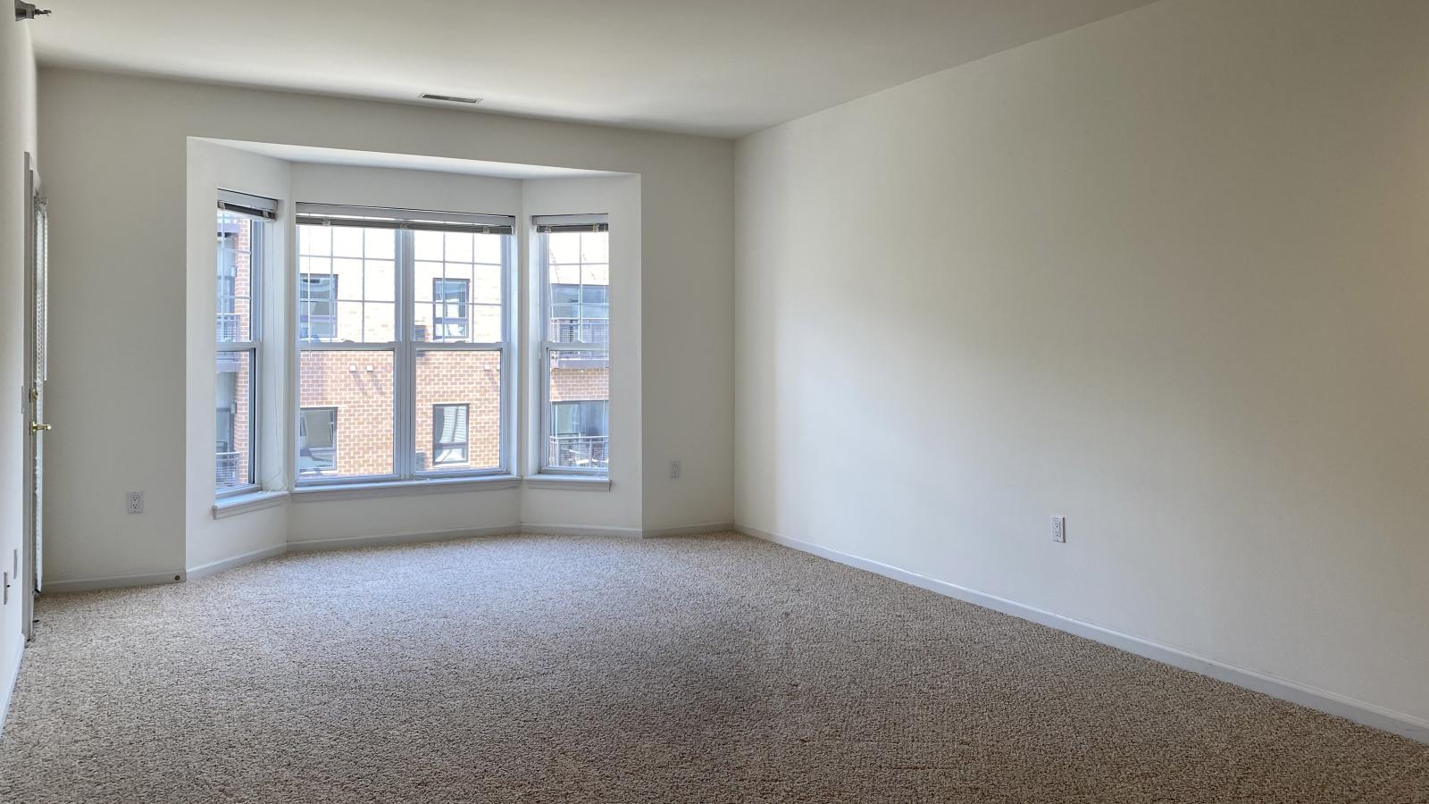 Living room with soft finishes, bay windows, and private balcony at City Place
