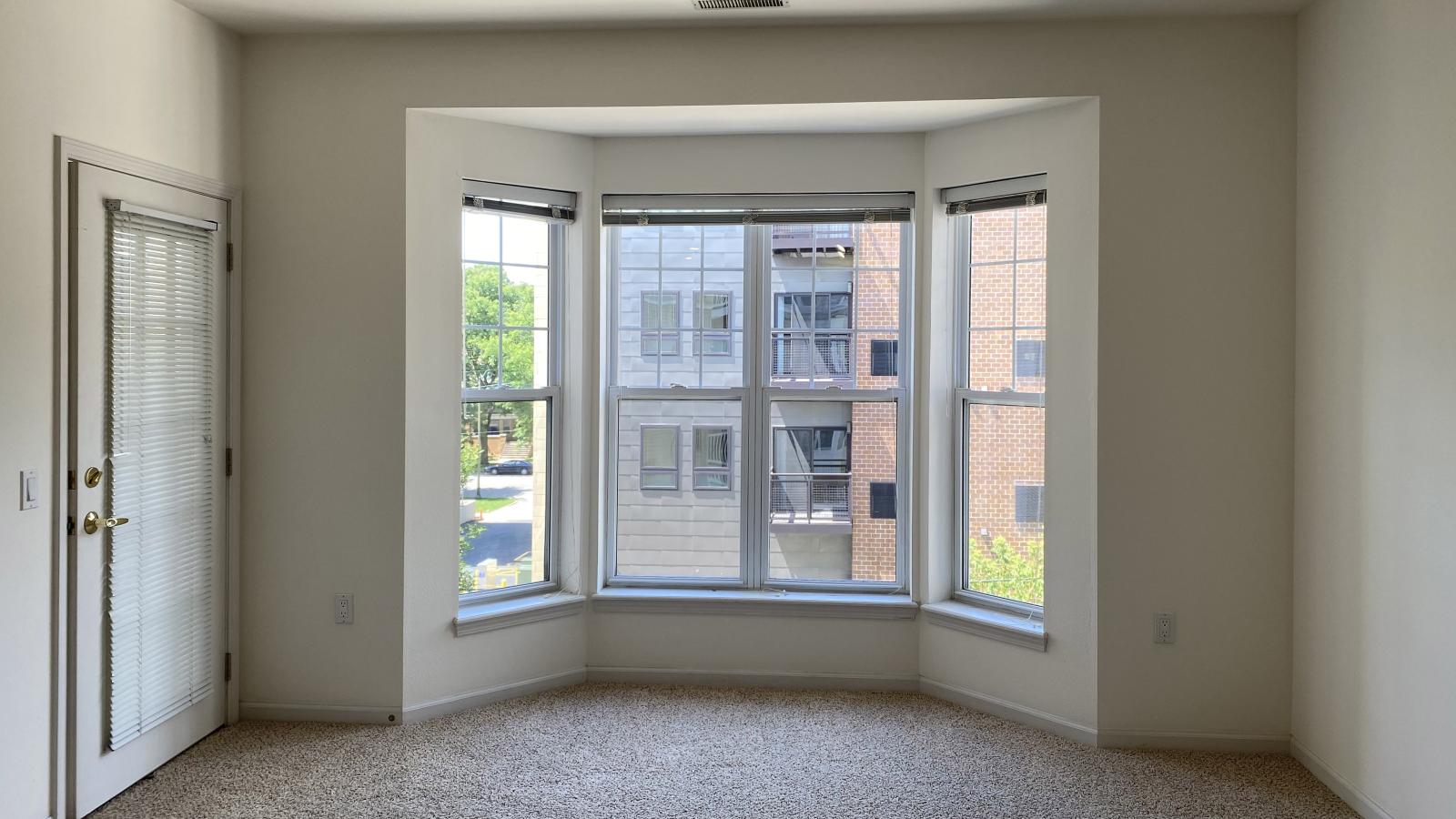 Living room with large bay windows and natural light in a one-bedroom apartment at City Place