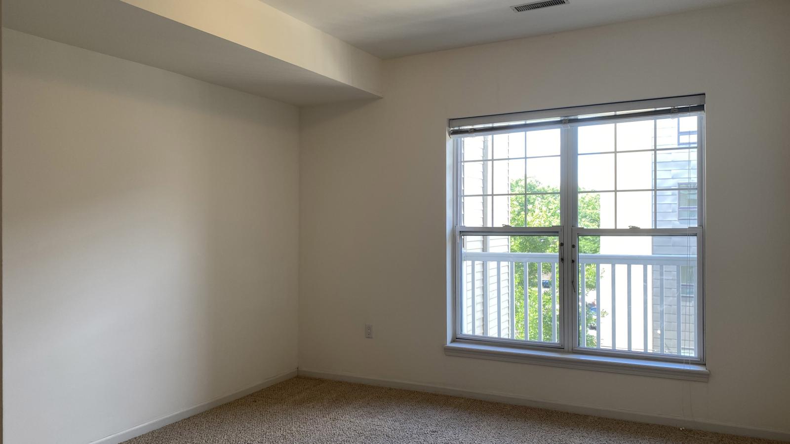 Bright bedroom with large windows, ample closet space, and soft finishes at City Place