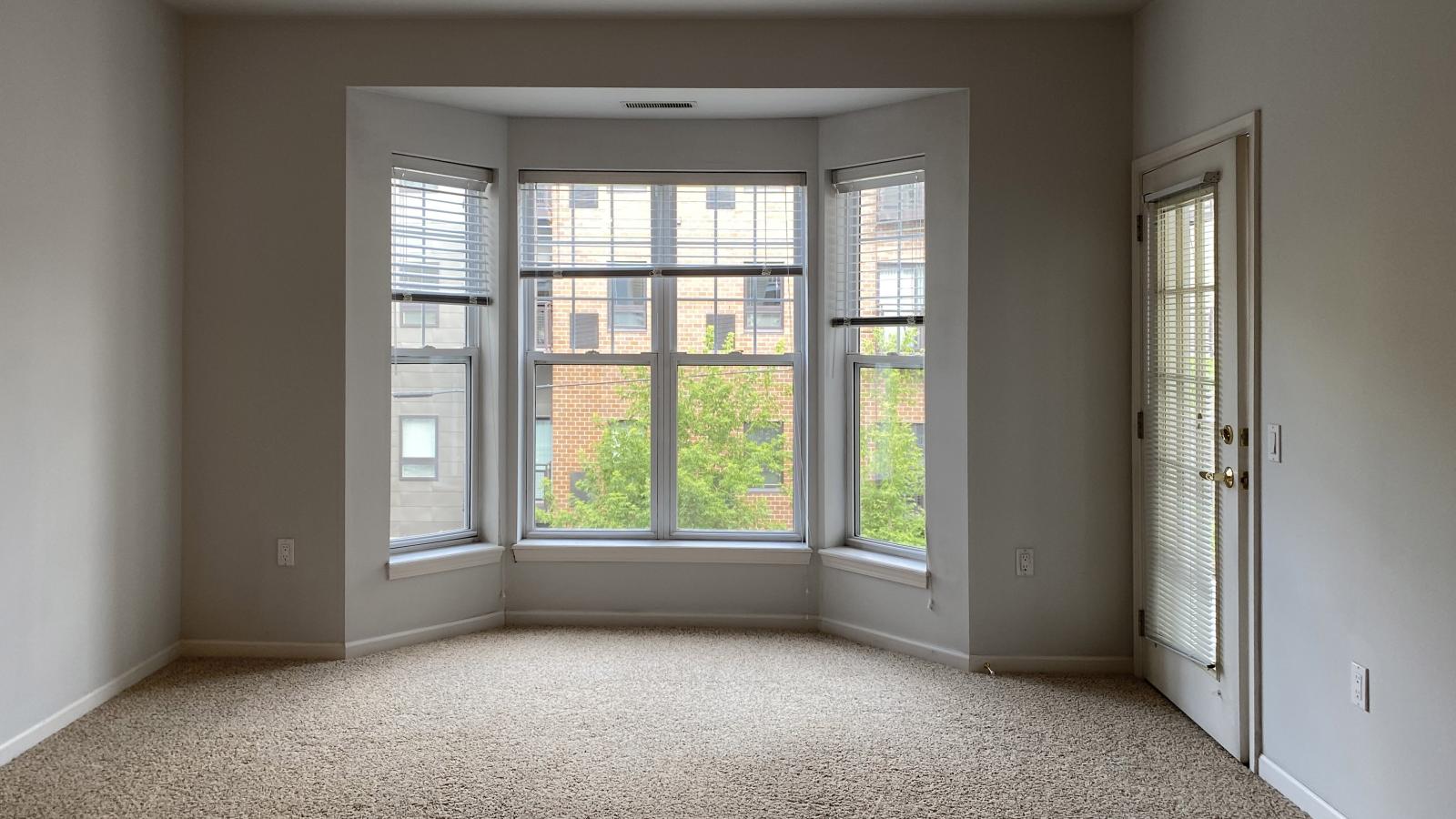Living room with large bay windows and natural light in a one-bedroom apartment at City Place