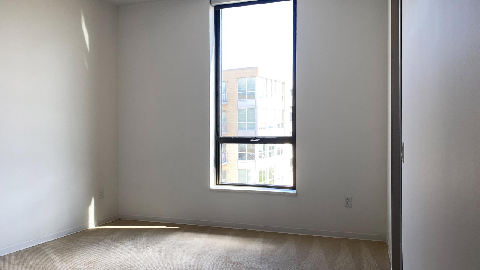 Bedroom with expansive windows and lake views in a two bedroom apartment at SEVEN27