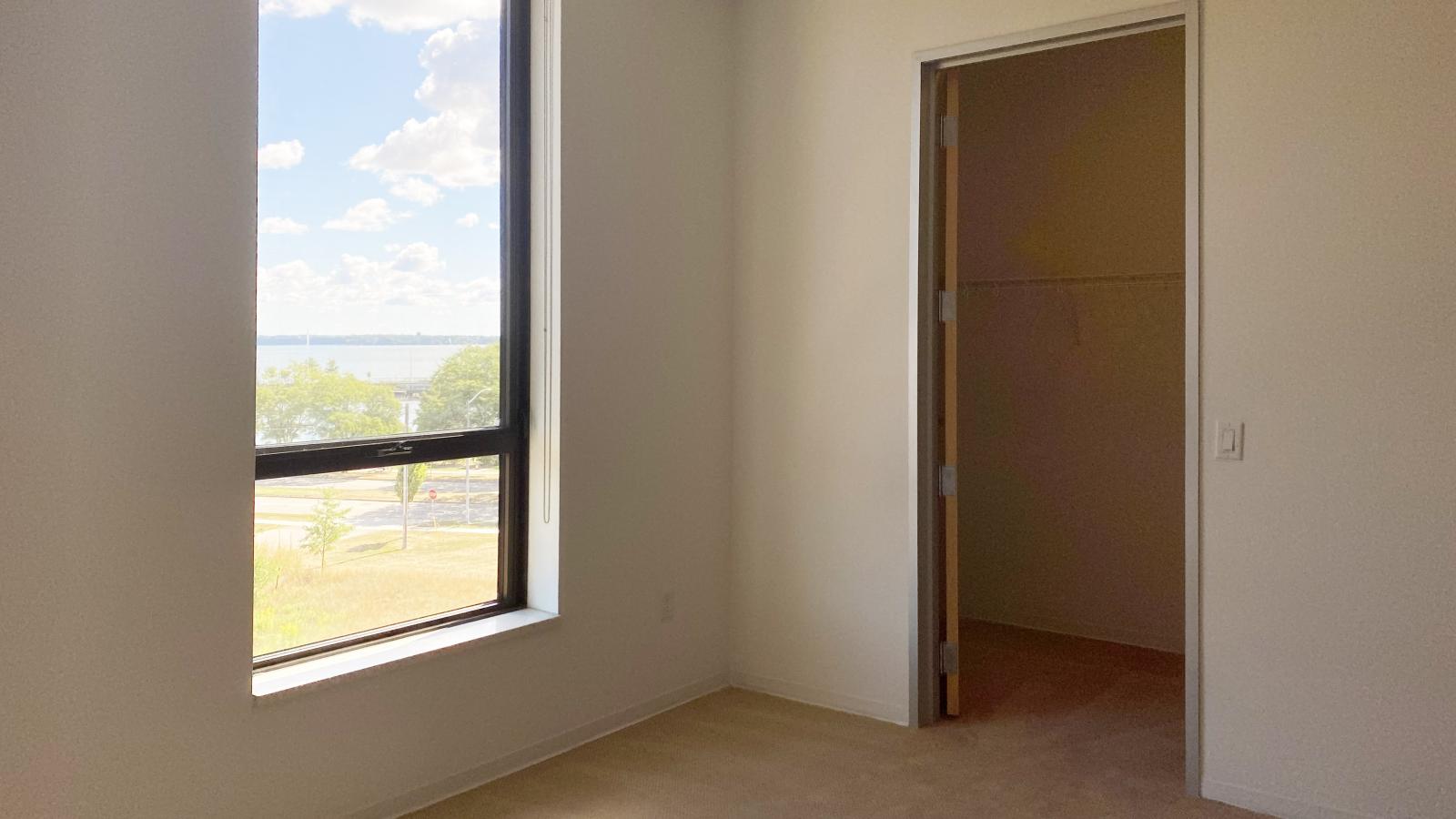 Bedroom with expansive windows and lake views in a two bedroom apartment at SEVEN27