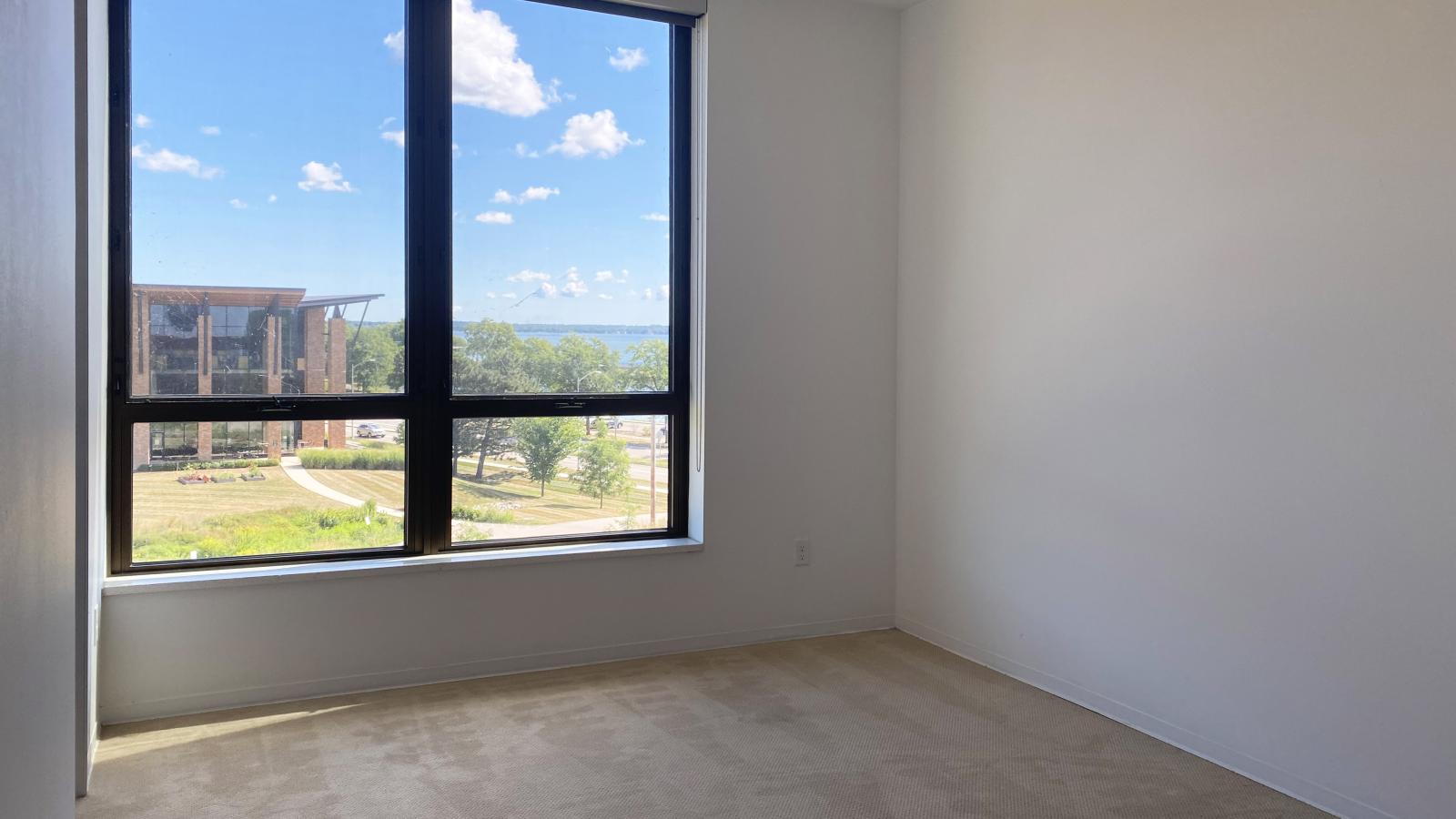 Bedroom with expansive windows and lake views in a two bedroom apartment at SEVEN27