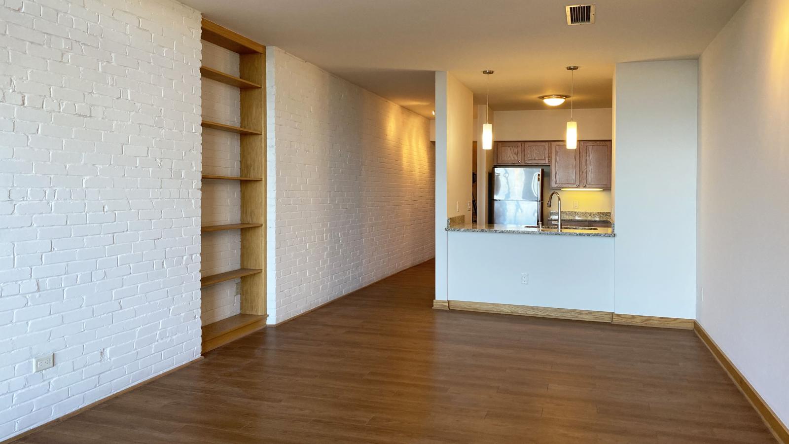 One-bedroom plus den apartment with exposed brick, built in shelves, private balcony and Lake Mendota views at Lincoln School