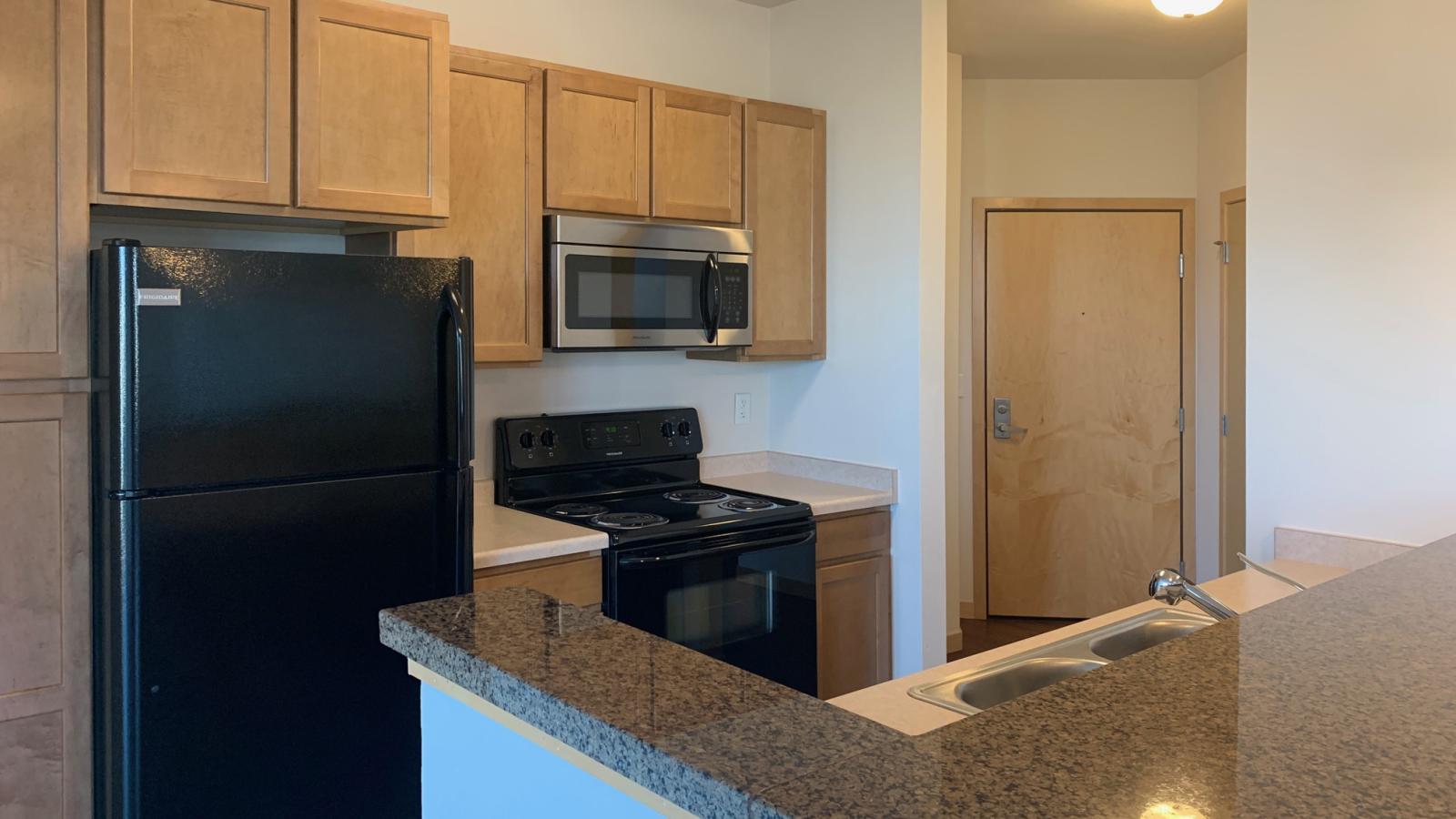 Two bedroom den apartment with standard kitchen appliances and generous living space at The Depot in downtown Madison