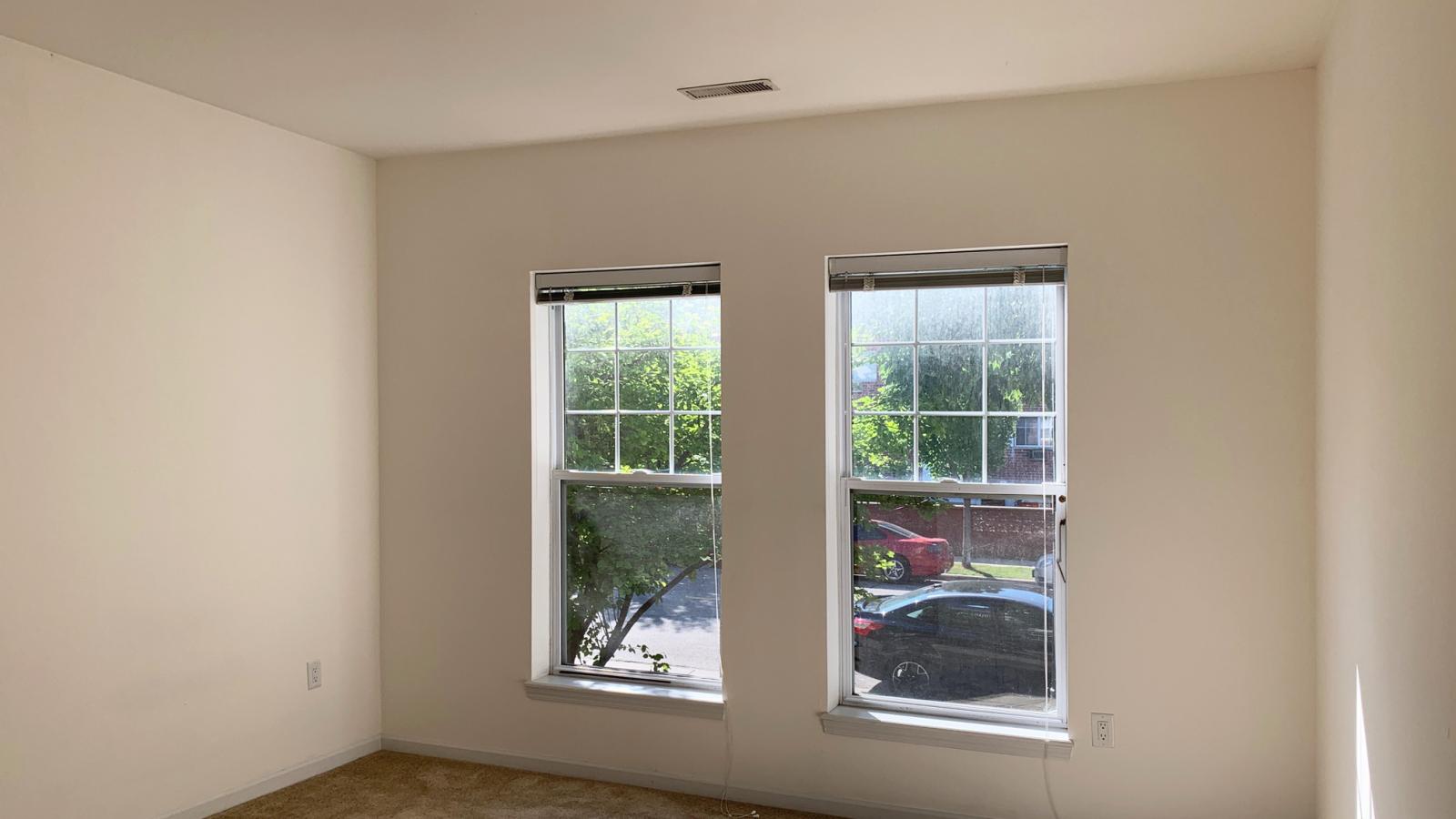 Bright bedroom with large windows and soft finishes at City Place