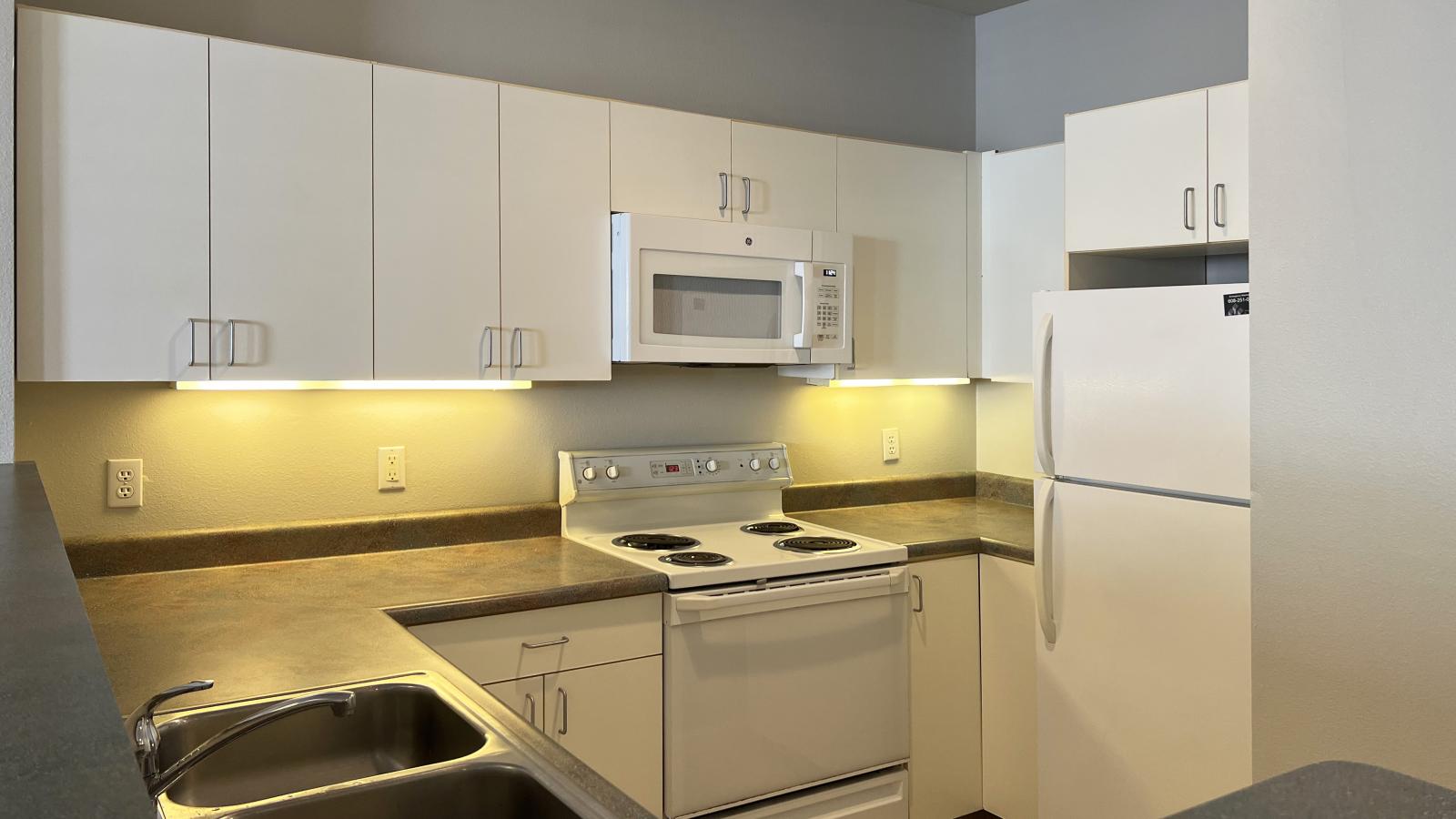 Kitchen with classic cabinetry and full-size appliances in a one-bedroom at Wilson Bay