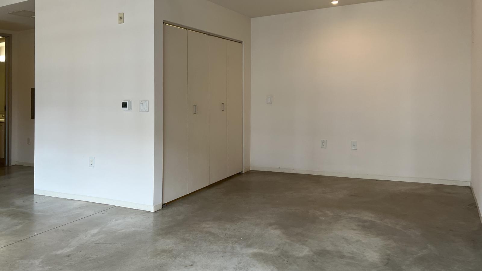 Industrial-inspired studio with polished concrete flooring and modern fixtures at Tobacco Lofts