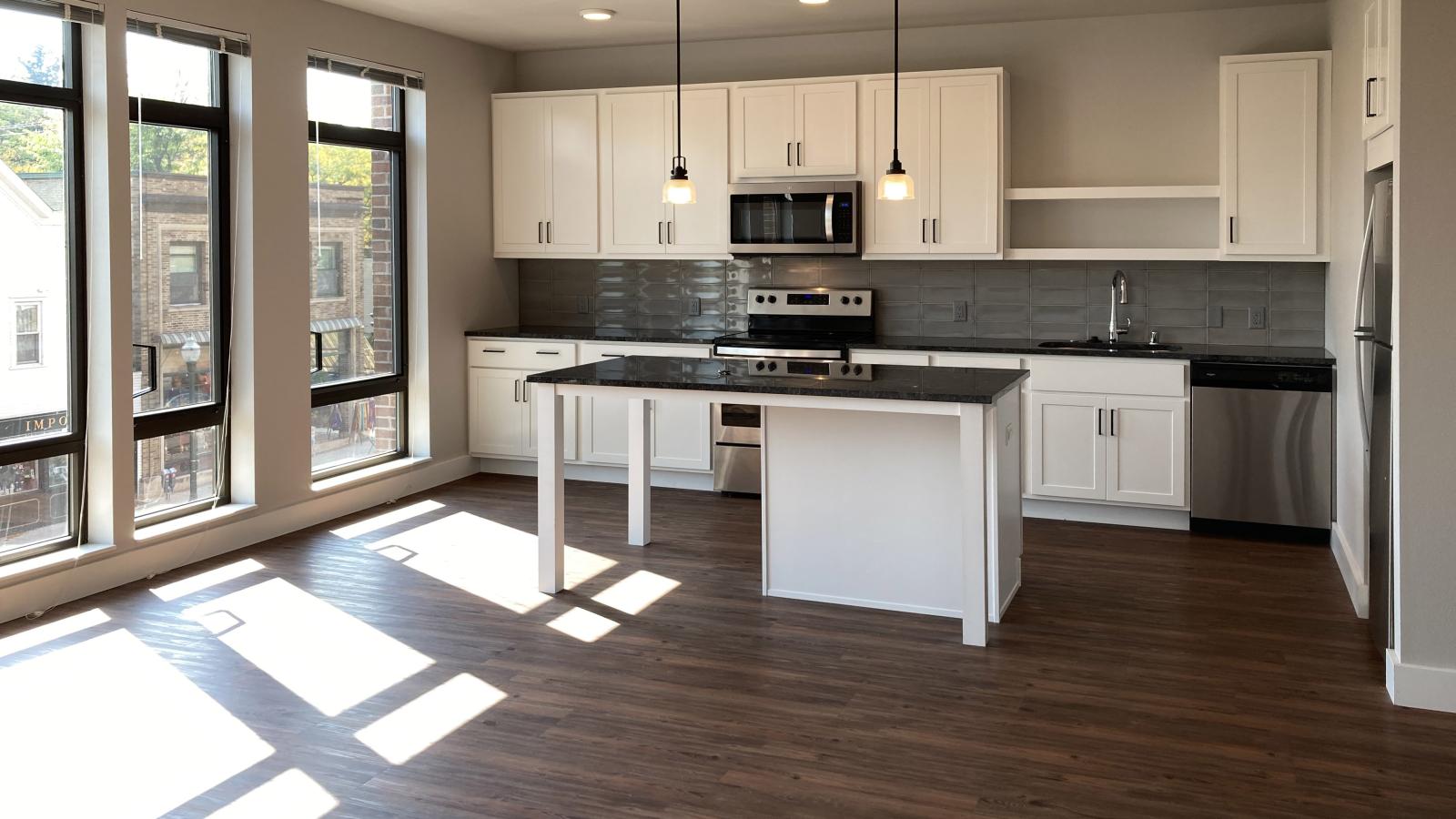 Modern kitchen in a 1722 Monroe apartment in Madison with white cabinetry, quartz countertops, and stainless steel appliances.