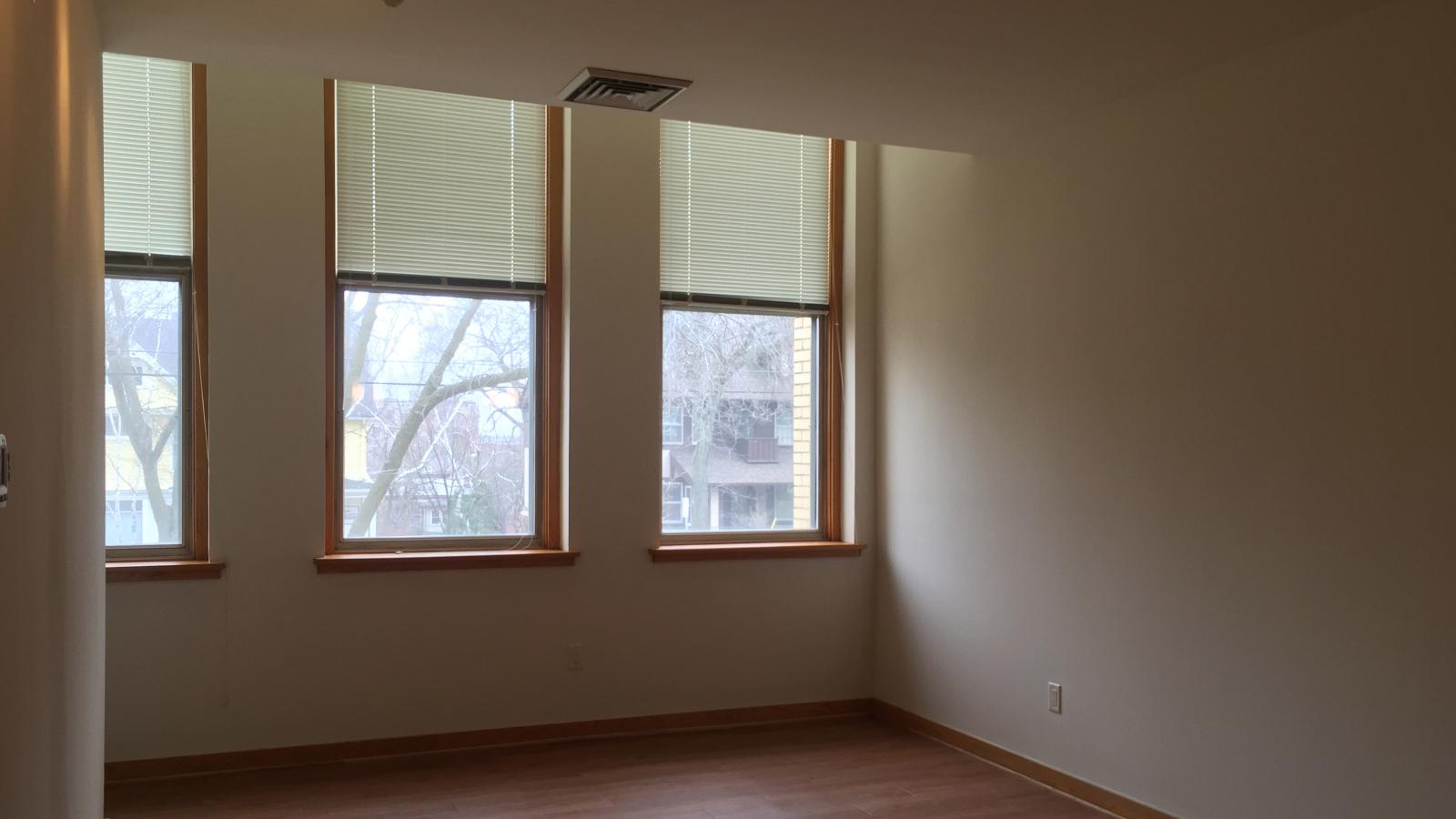 Spacious living room with historic charm and natural light in a one-bedroom apartment at Lincoln School