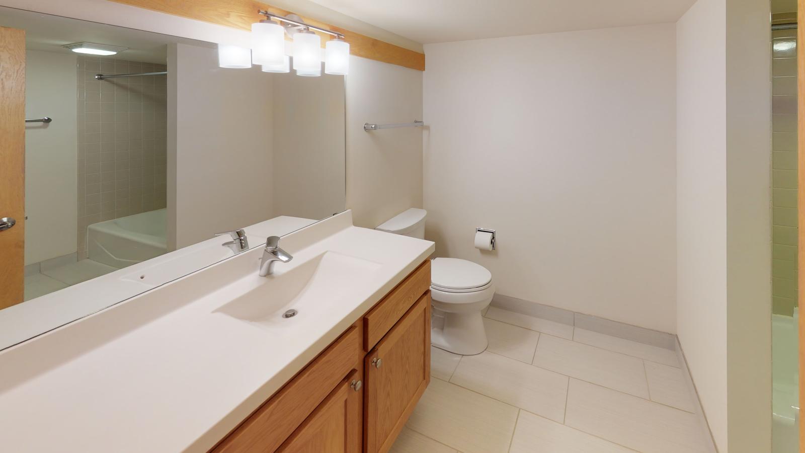 Classic bathroom with tiled finishes and warm lighting at Lincoln School