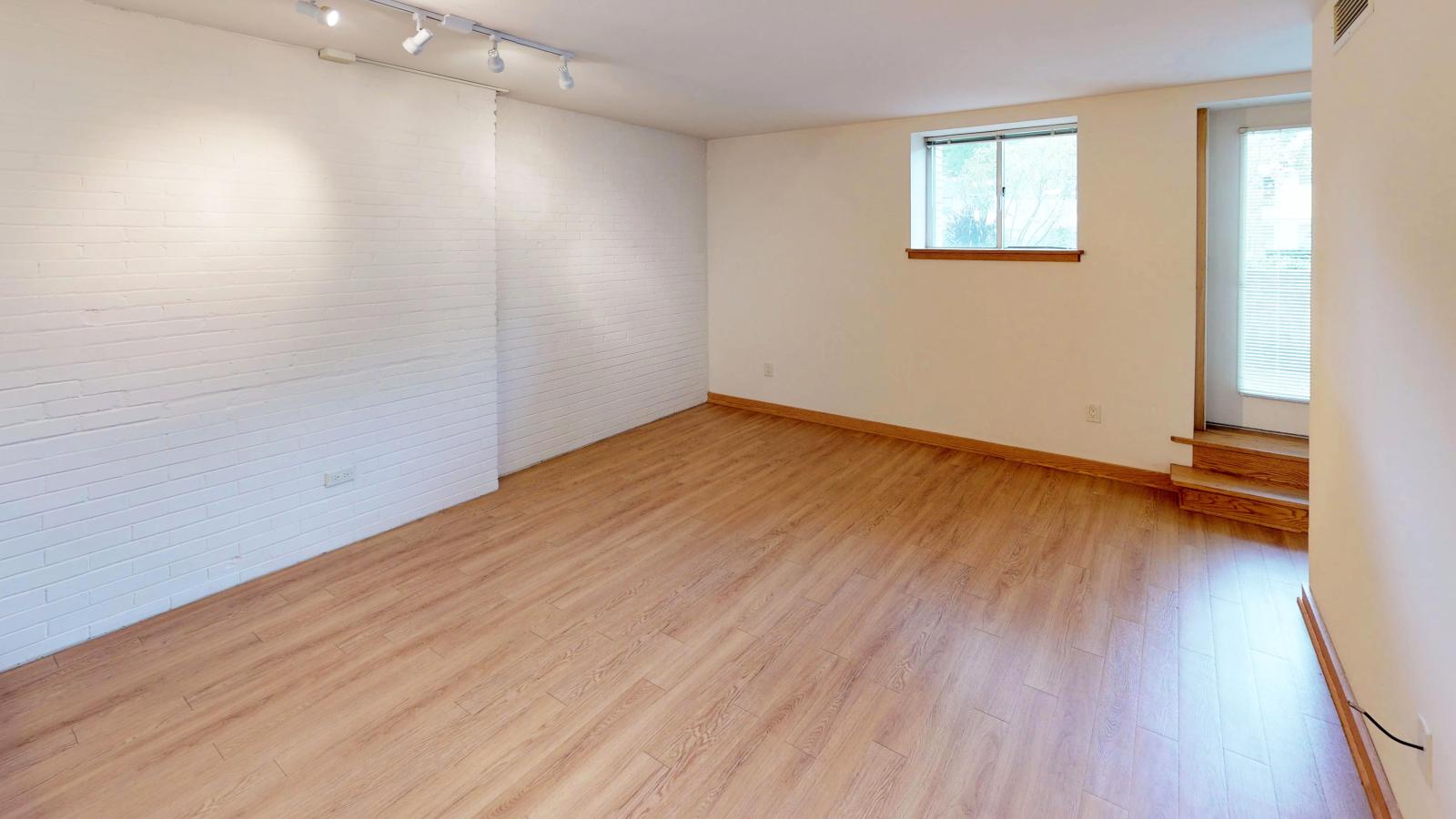 One-bedroom apartment with exposed brick and garden-level patio at Lincoln School in downtown Madison