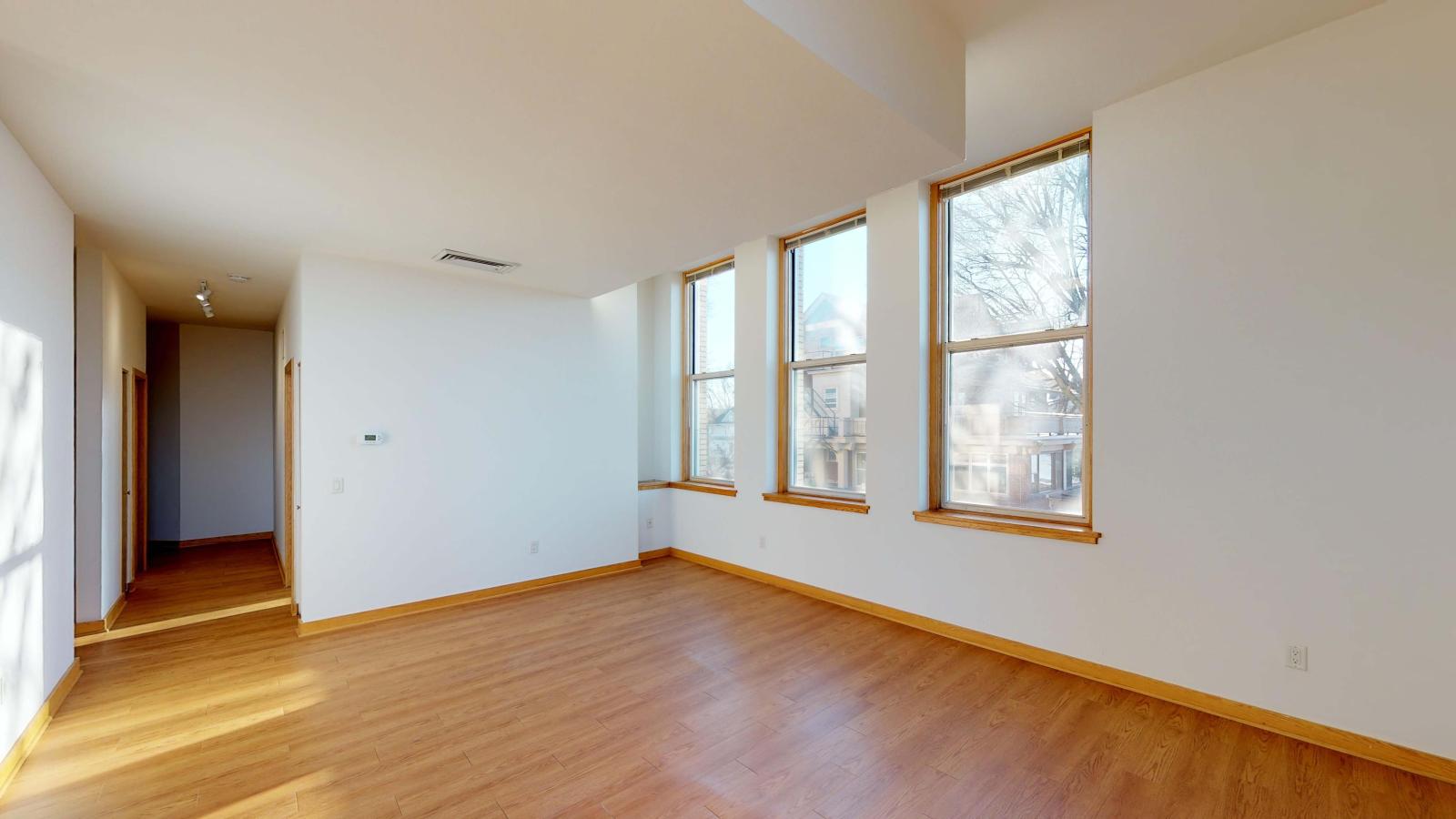 Spacious living room with historic charm and natural light in a one-bedroom apartment at Lincoln School