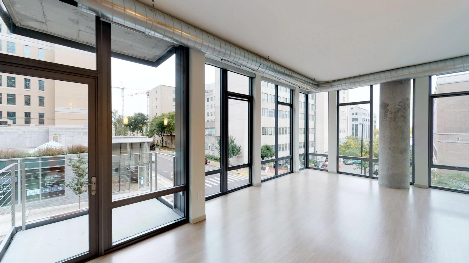 Modern two-bedroom apartment at The Pressman Apartments in downtown Madison with a private balcony and an open living space.