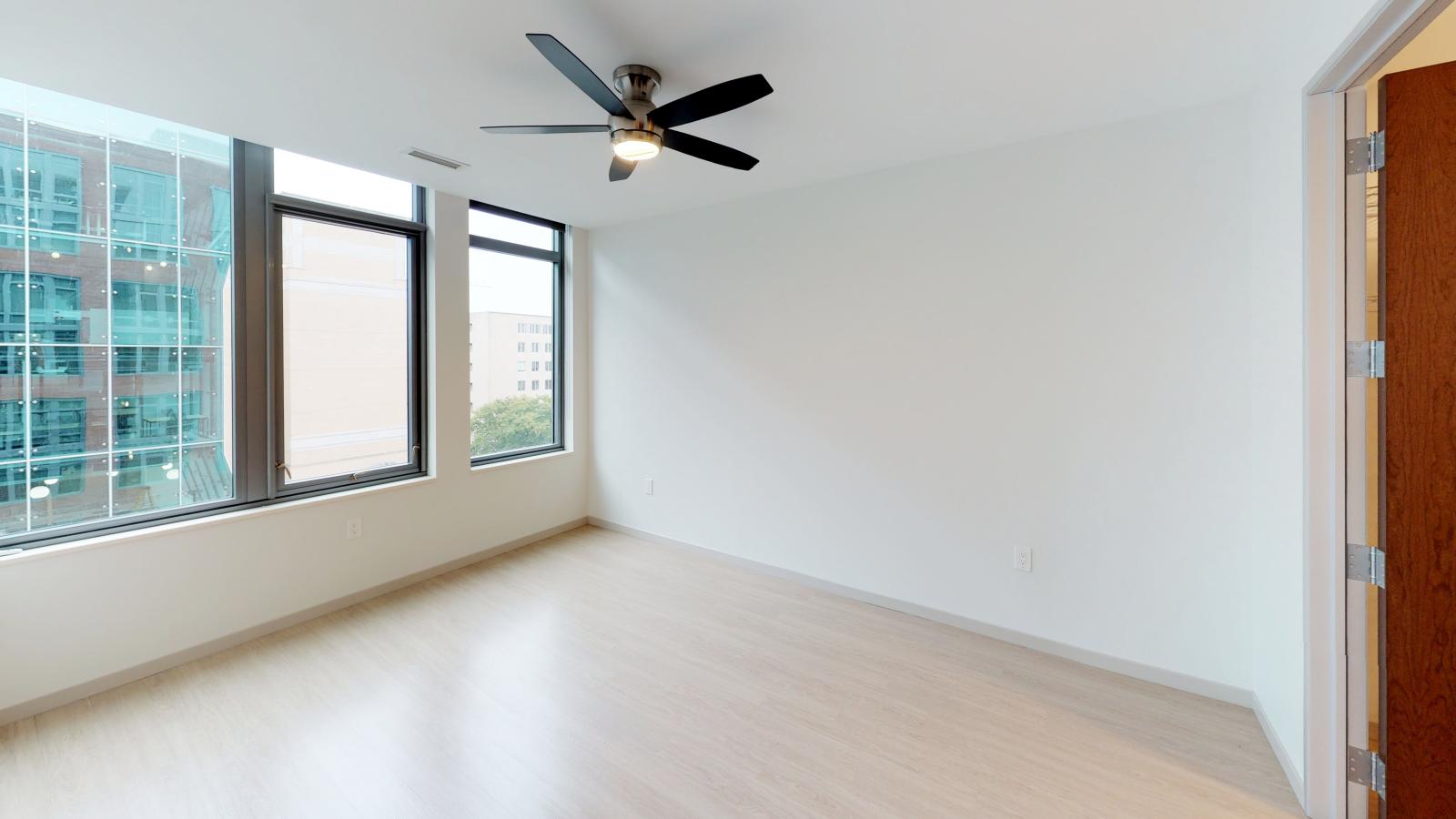 Stylish apartment bedroom at The Pressman in downtown Madison with large windows and ample closet space.