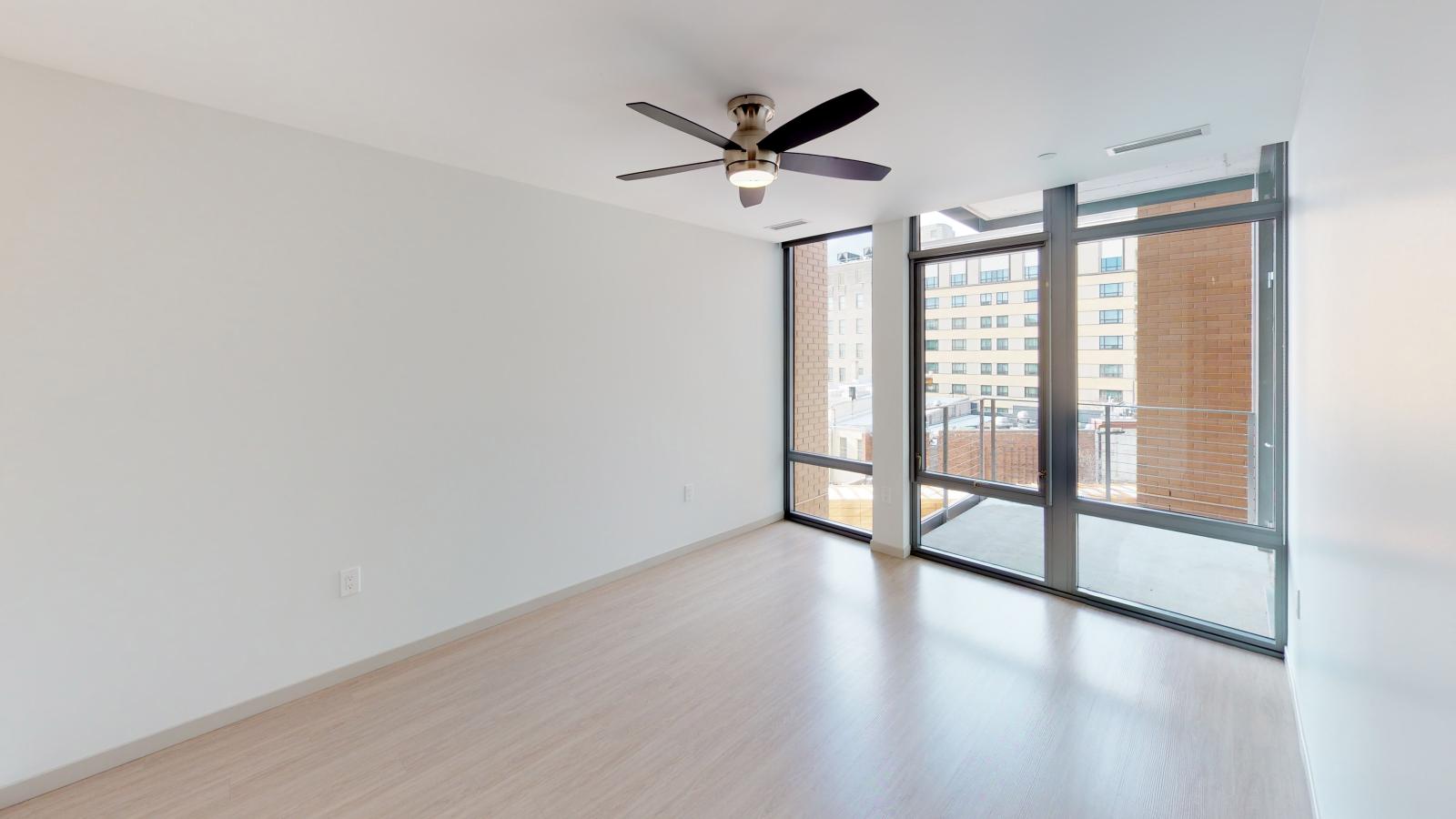Stylish apartment bedroom at The Pressman in downtown Madison with large windows and ample closet space.