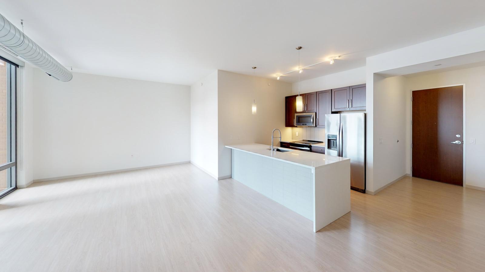 The Pressman apartment in downtown Madison featuring an open-concept kitchen with a glass tile backsplash and high-end finishes.