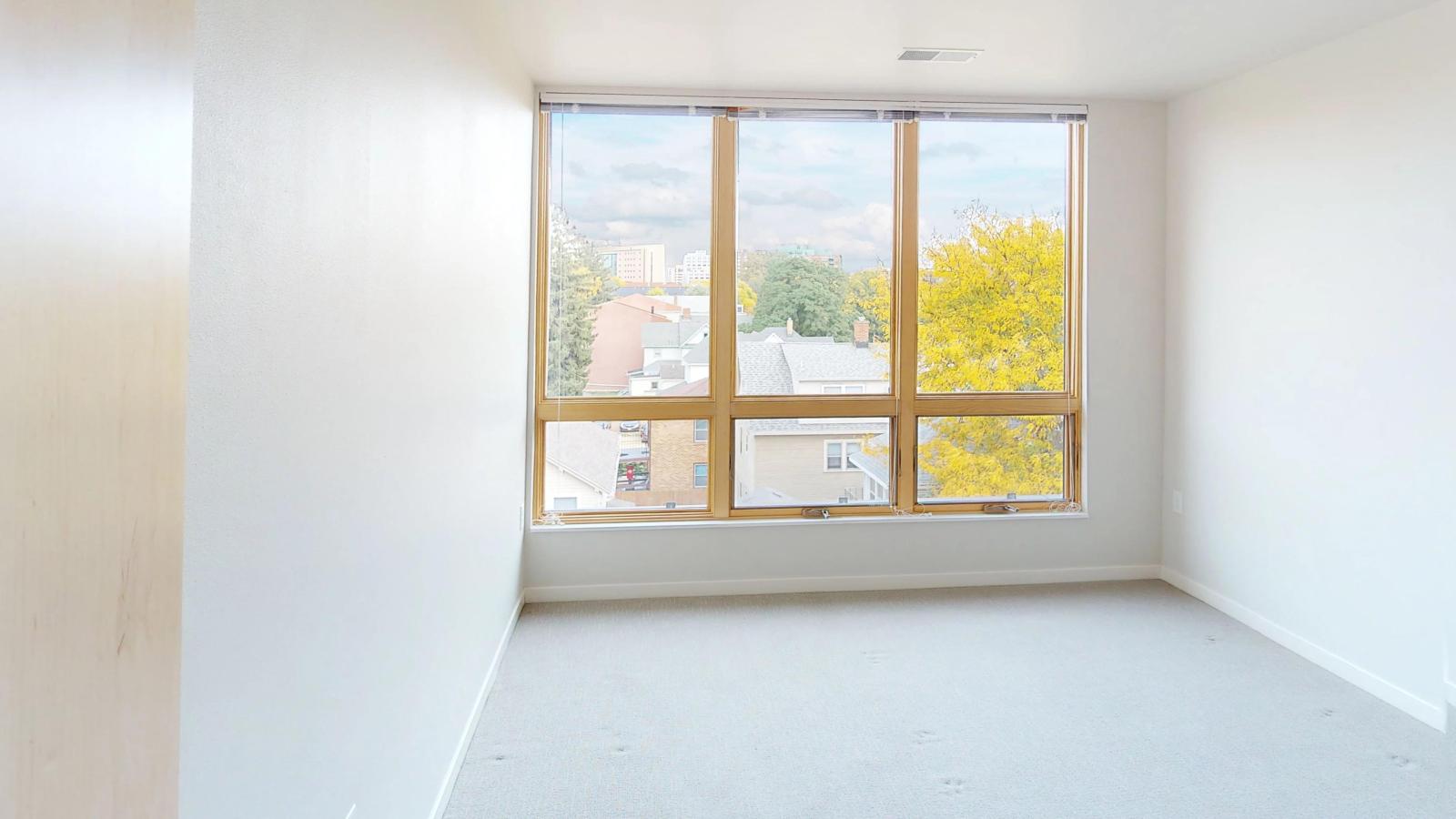 Bright and stylish three-bedroom apartment at Quarter Row Apartments in downtown Madison with large windows and sleek modern features.