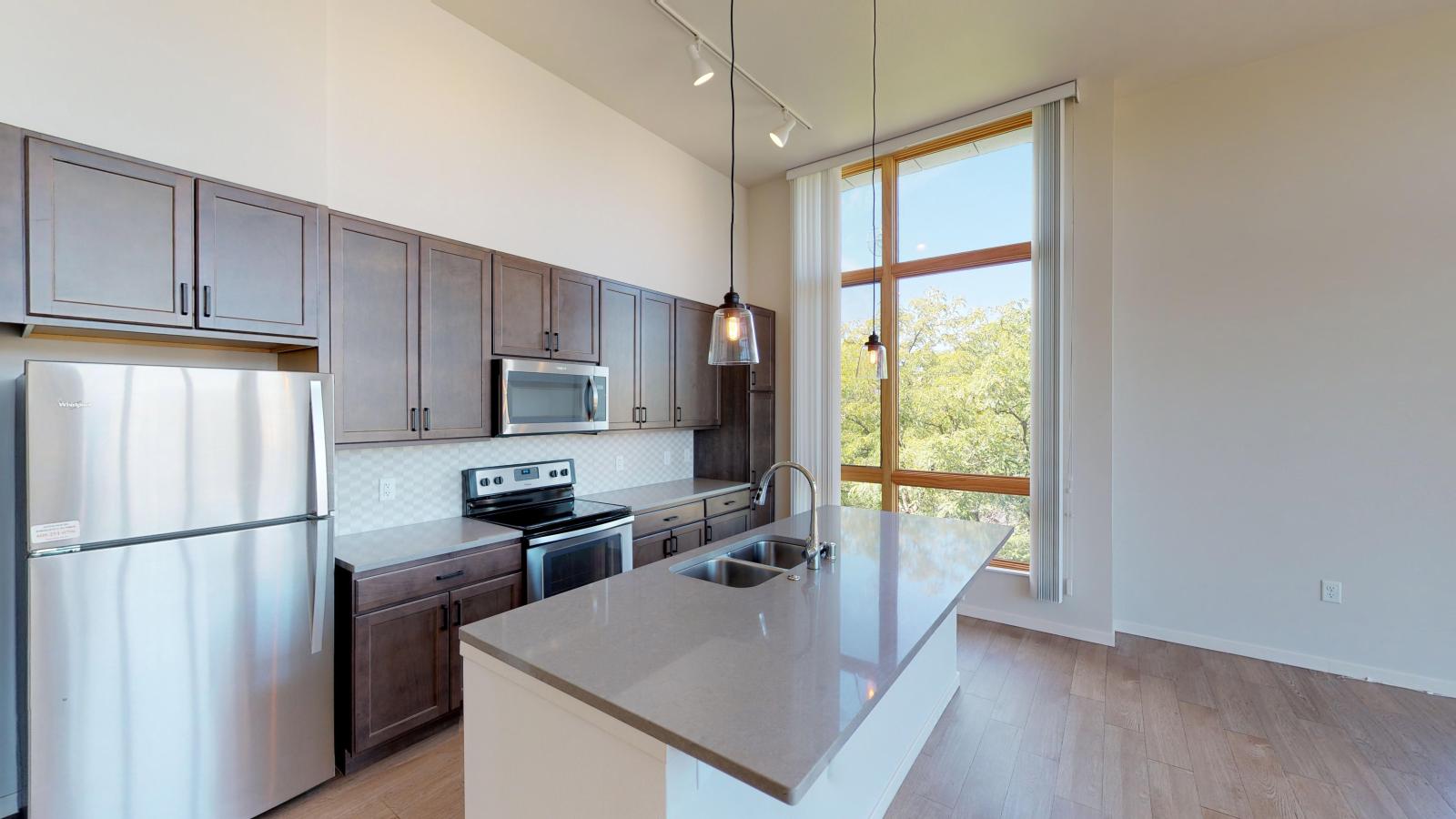 Bright and modern two-bedroom apartment at Quarter Row Apartments in downtown Madison featuring a contemporary kitchen and spacious layout.